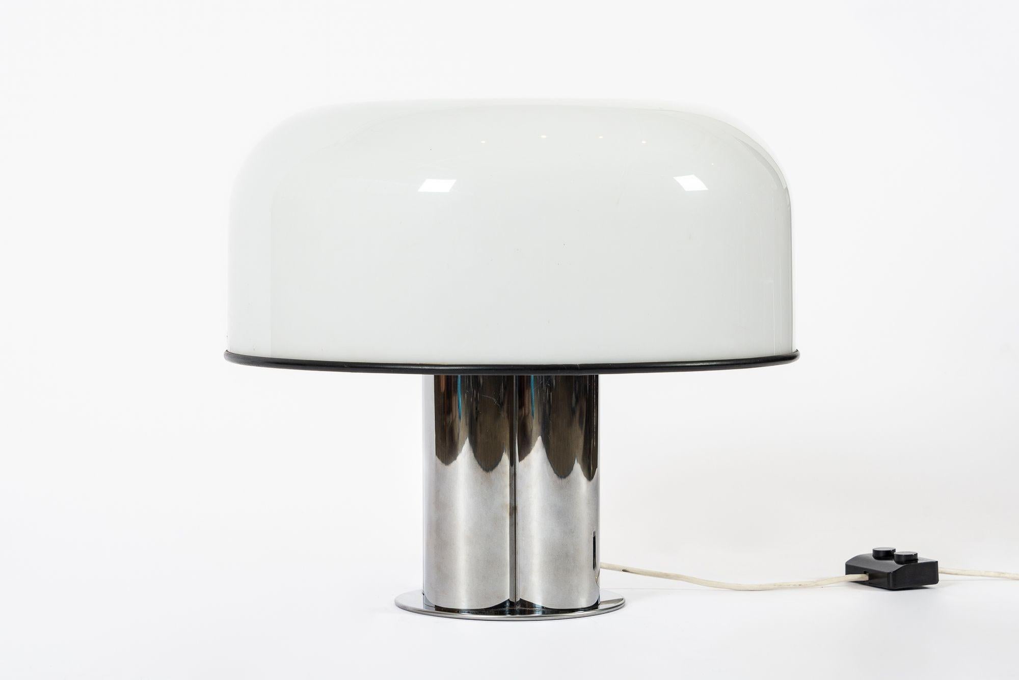 Cette très grande lampe de table vintage de l'ère spatiale du milieu du siècle, blanche et argentée, par Harveiluce pour iGuzzini, a été fabriquée en Italie vers 1970. Cette lampe design est bien construite avec un grand abat-jour en plastique