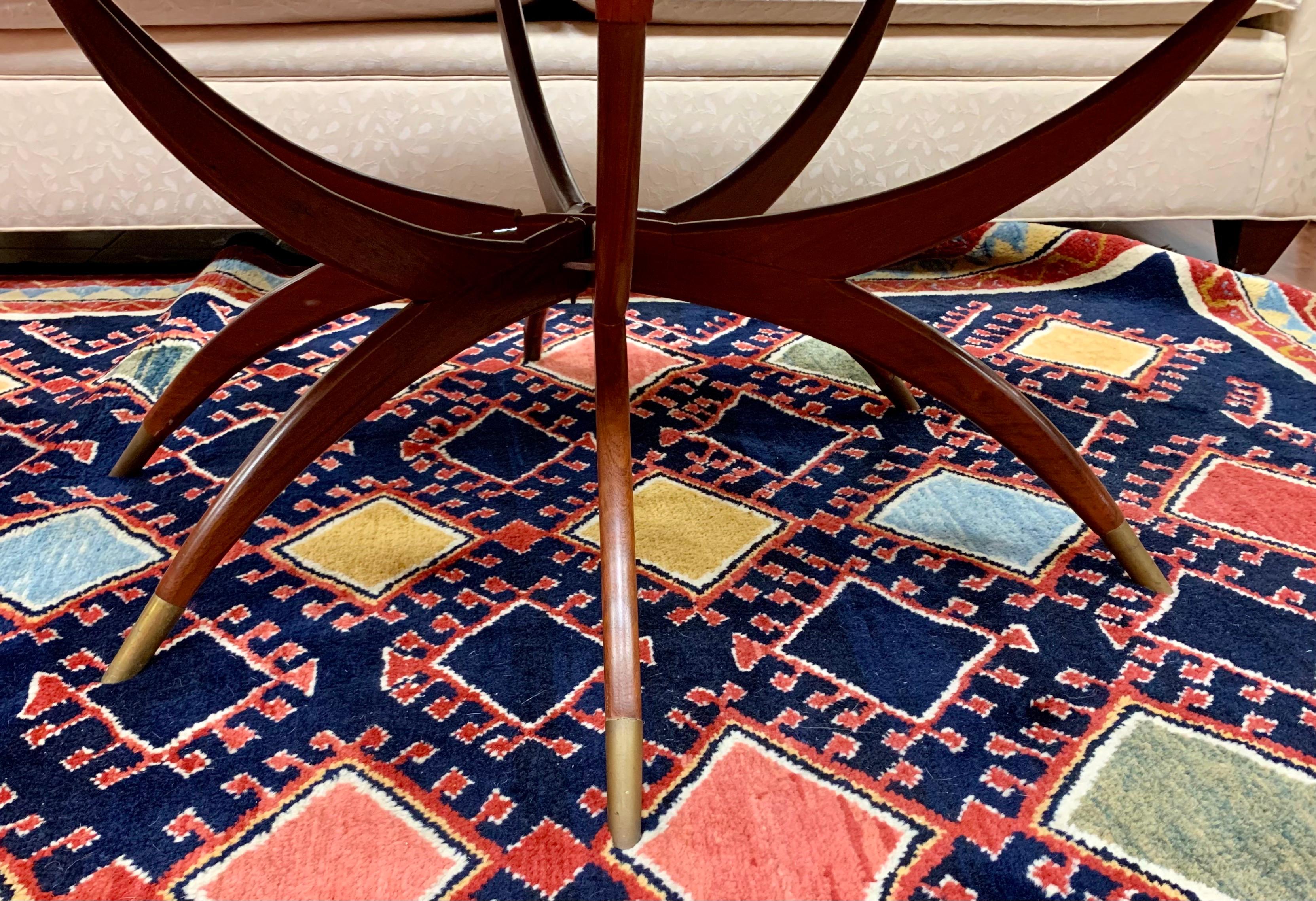 Table plateau en laiton poli de style mauresque du Moyen-Orient du milieu du siècle, avec un bord ébouriffé reposant sur une base pliante en acajou. Chaque pied est muni d'une protection en laiton et s'ouvre sur une base en forme d'étoile. Le