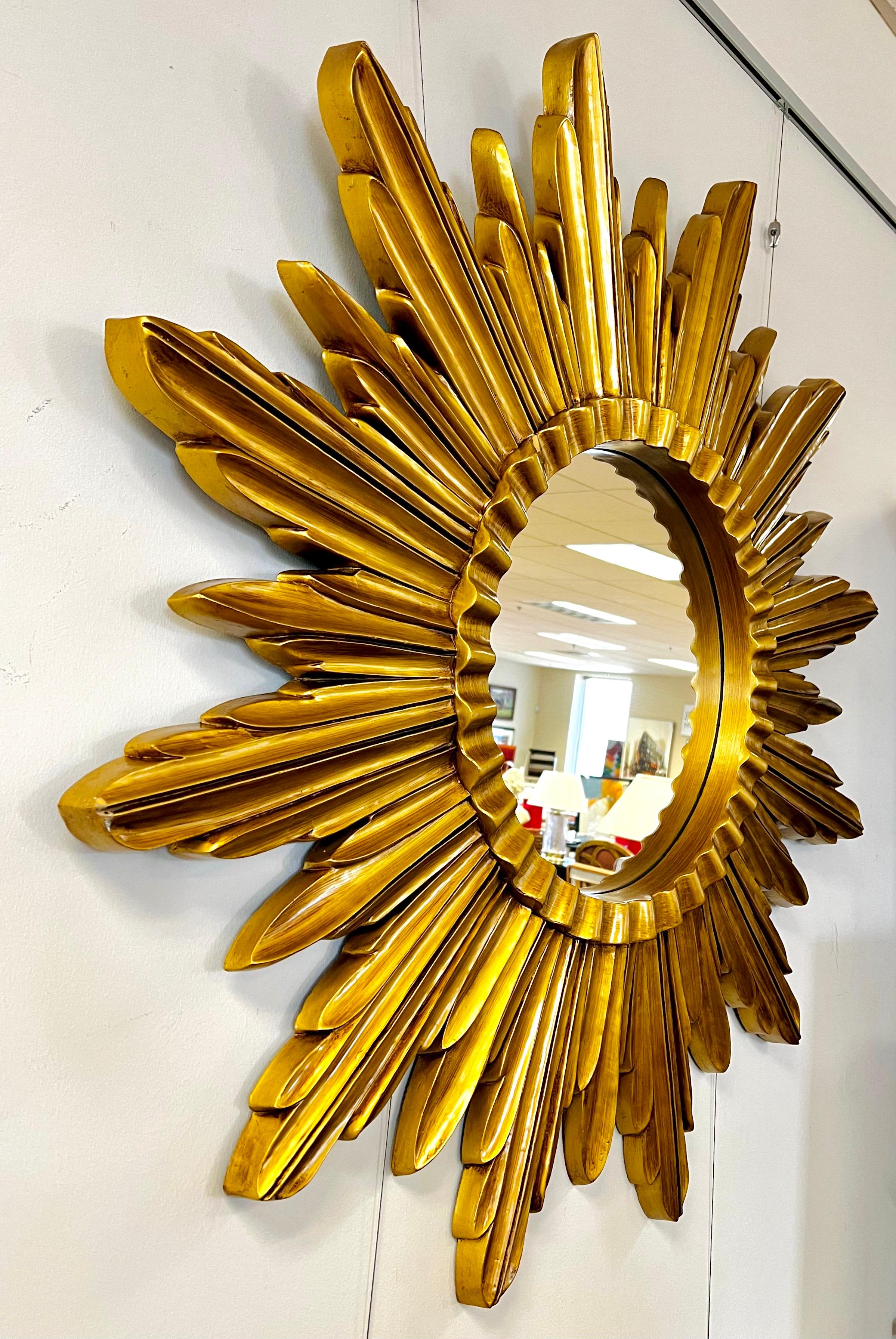 Extra large mid century gold starburst/sunburst mirror.  This mirror will create a dazzling display and compliment both modern and traditional style interiors.  It is made of some sort of composite/resin that looks like wood - but isn't.  Perfect
