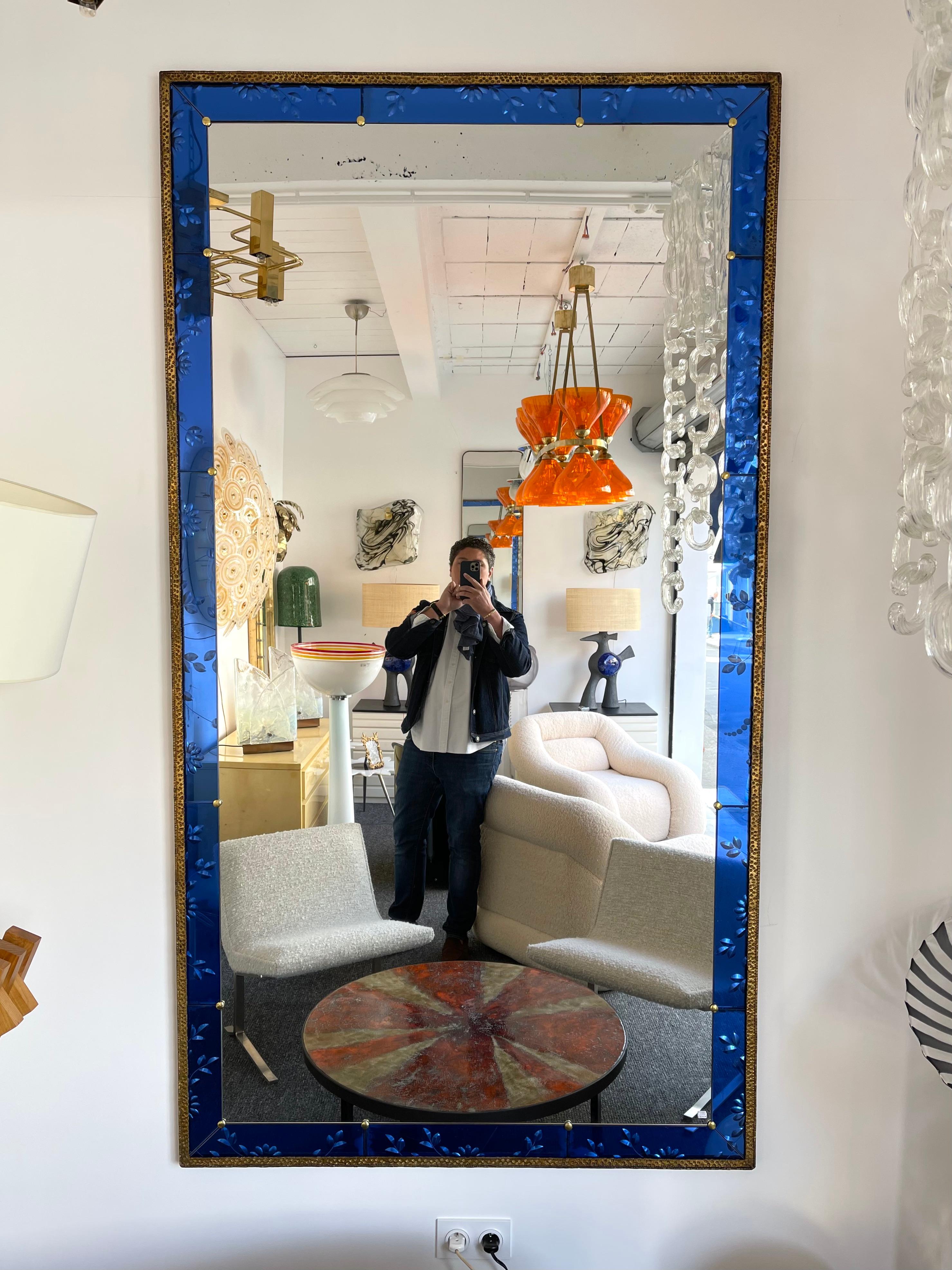 Extra large wall or full-length mirror blue engraving glass with gilt hammered wrought iron frame, brass details by the italian manufacture Pier Luigi Colli very probably a collaboration with the manufacture Cristal Art. Famous manufacture like