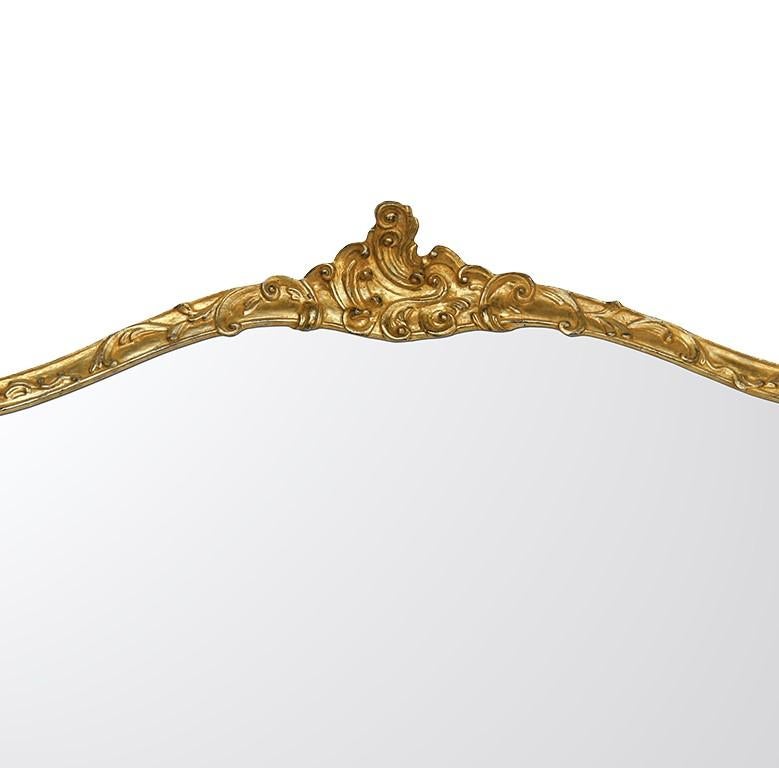 This magnificent, extra large mirror is a superb example of traditional craftsmanship. The elongated frame of the piece is thin and elegant, exquisitely carved by hand to create the curls that adorn its entire profile. The frame was given a gold