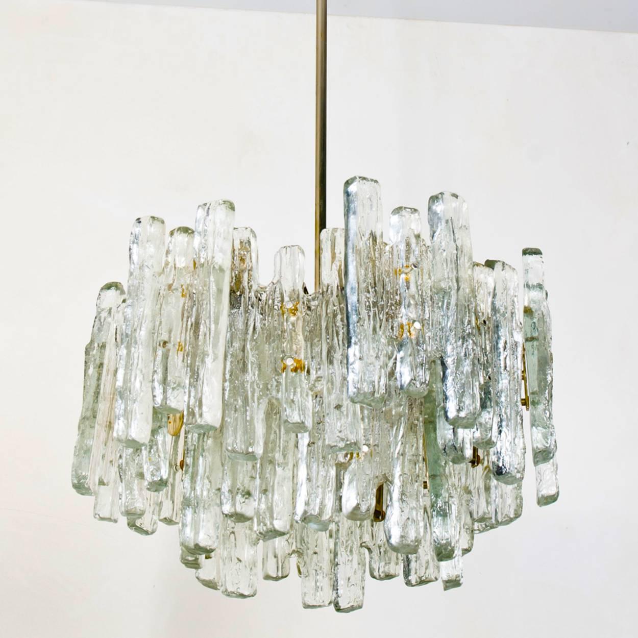A large and heavy beautiful and elegant modern chandelier, manufactured by Kalmar Austria in the 1960s. Lovely design, the chandelier has 18 sockets 40W and three layers of extremely stylish textured solid ice glass sheets dangling on it. This