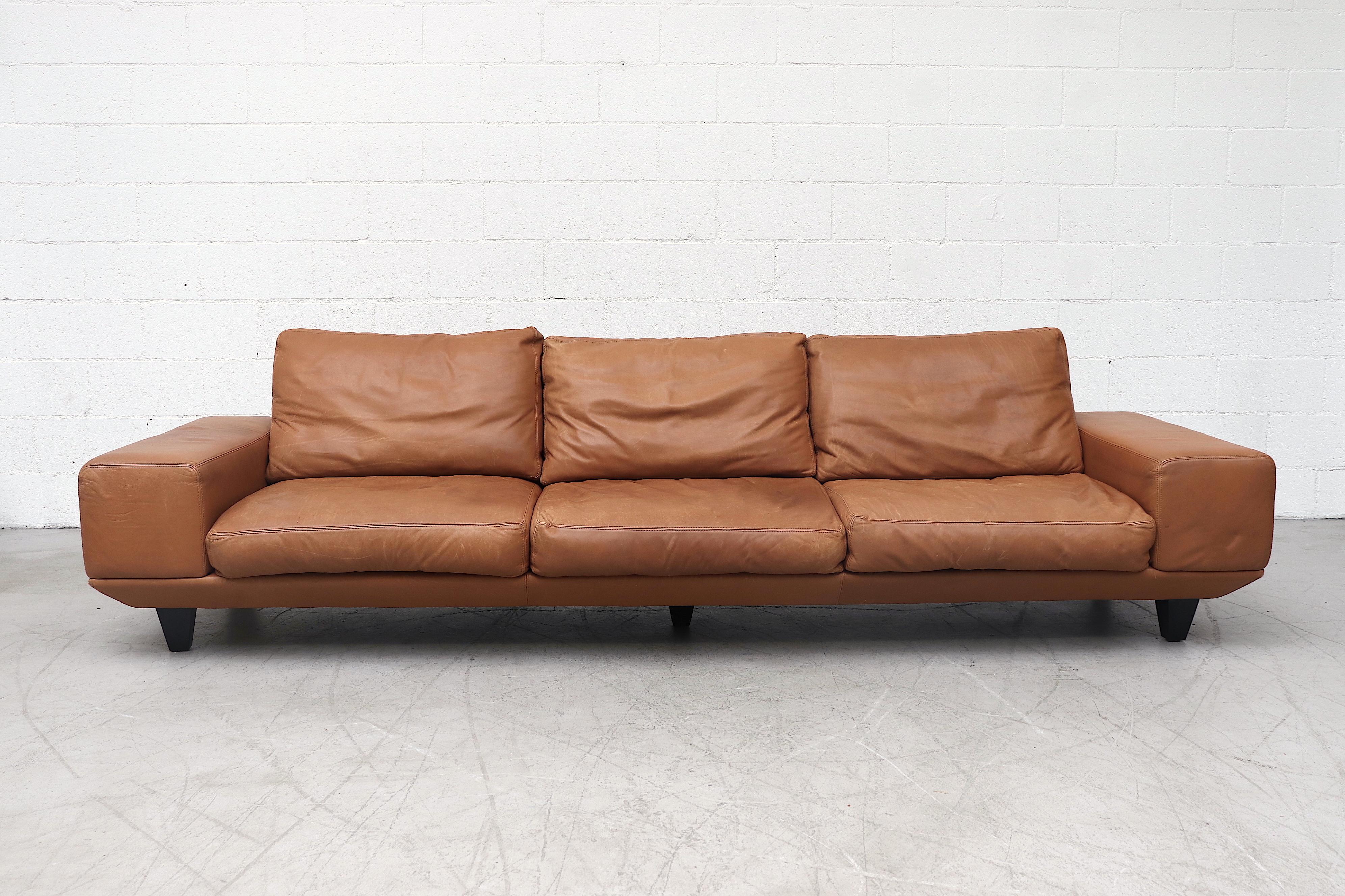Extra large Molinari cognac leather sofa with five sturdy wood legs supporting it's sizable frame. Gorgeous style with oversized armrests. Removable seat and back cushions connected by Velcro. In original condition with wear consistent with age and