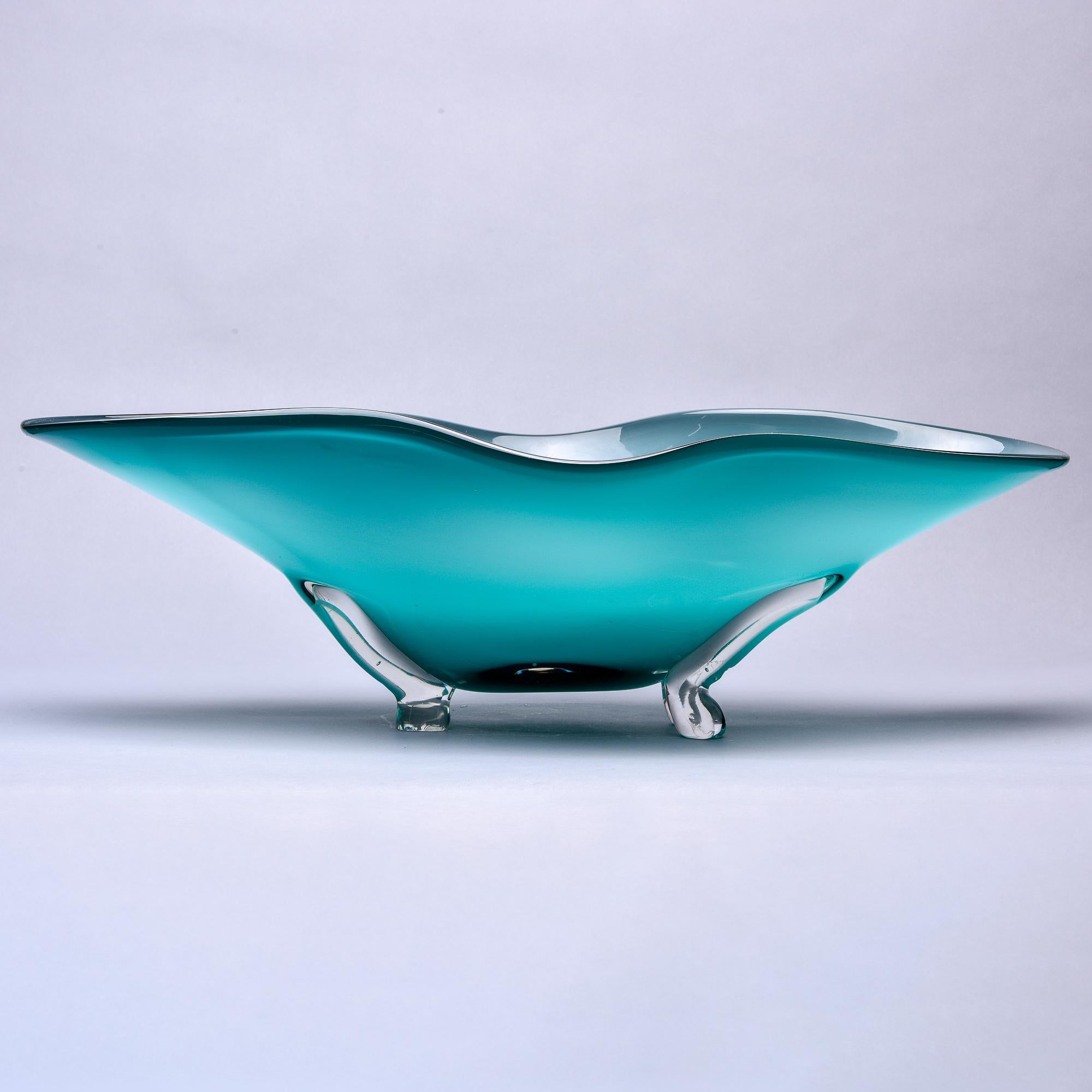 Found in Italy, this circa 1994 extra large Murano glass center bowl has a clear footed base and wide, flared blue-green bowl that is 26” wide. Unknown maker. Etched Murano 1994 on underside of base.
