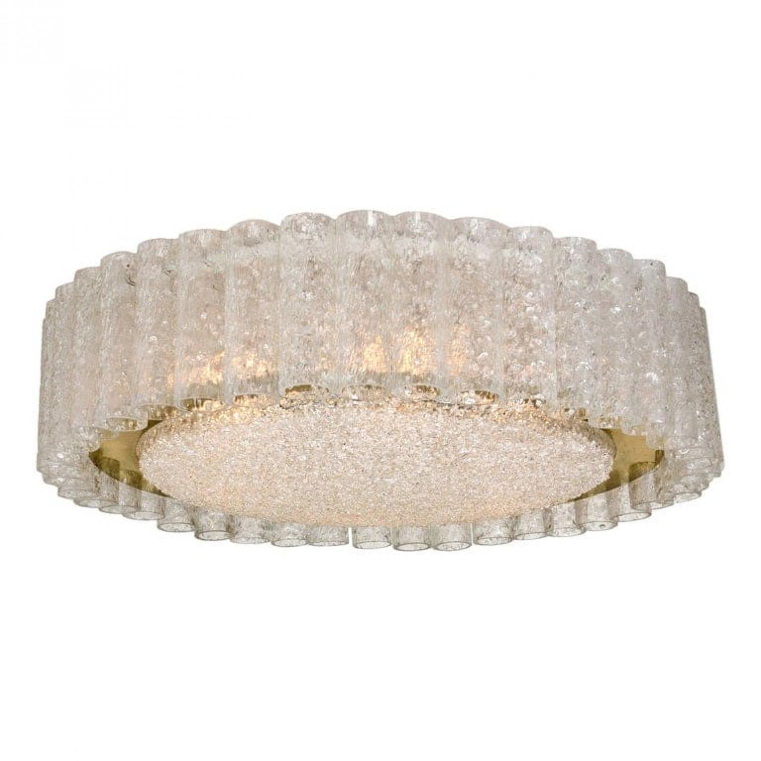 Un très grand lustre encastré Doria, des tubes de verre organiques entourant un diffuseur central en verre monté avec une quincaillerie apparente minimale avec un anneau en laiton pour un look propre et élégant.

Les plats en verre des luminaires