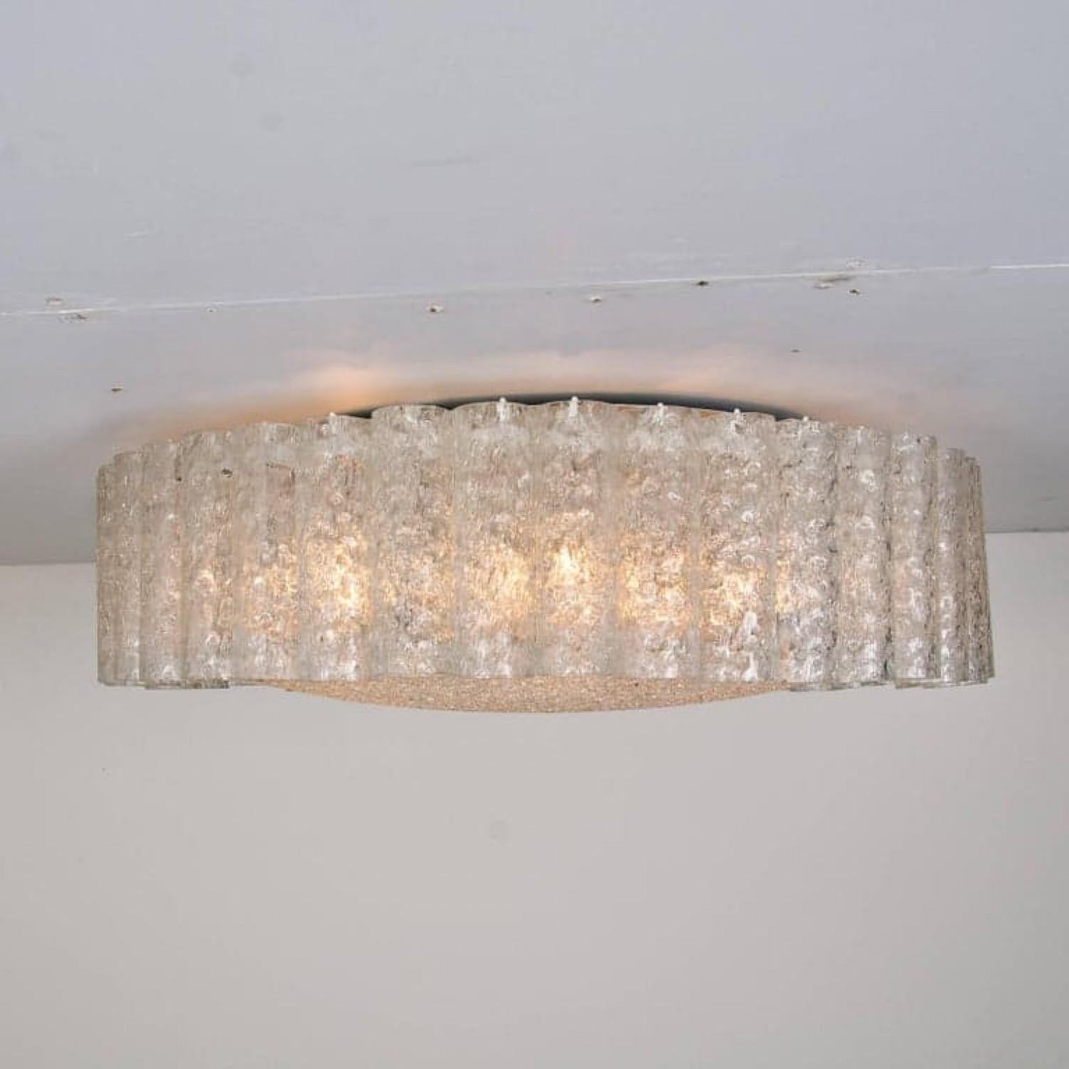 A extra large Doria flush mount chandelier, organic glass tubes surrounding a central glass diffuser mounted with minimal exposed hardware with a brass ring for a clean and elegant look.

The glass dishes of the fixtures are made of 'Frit' glass - A