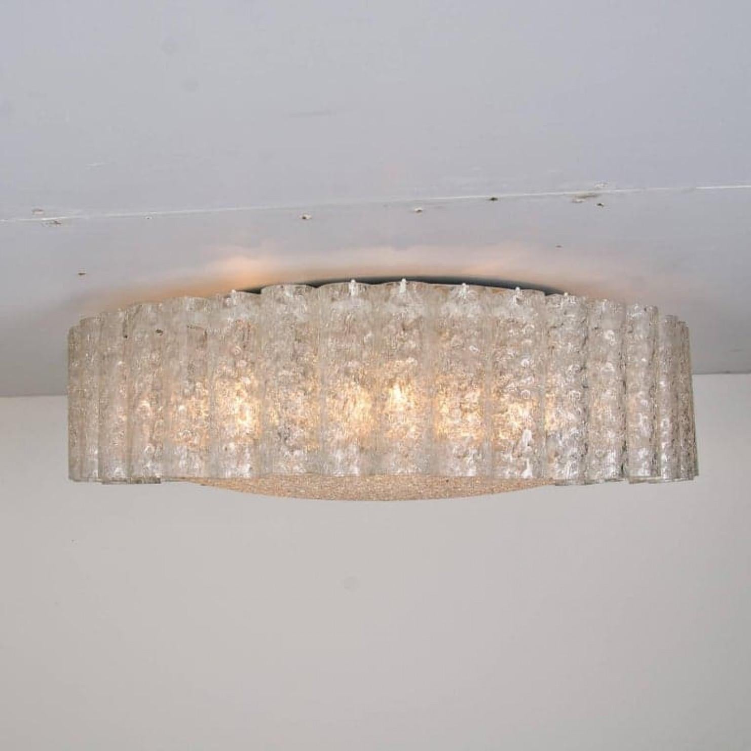 Un très grand lustre encastré Doria, des tubes de verre organiques entourant un diffuseur central en verre monté avec une quincaillerie apparente minimale avec un anneau en laiton pour un look propre et élégant.

Les plats en verre des luminaires