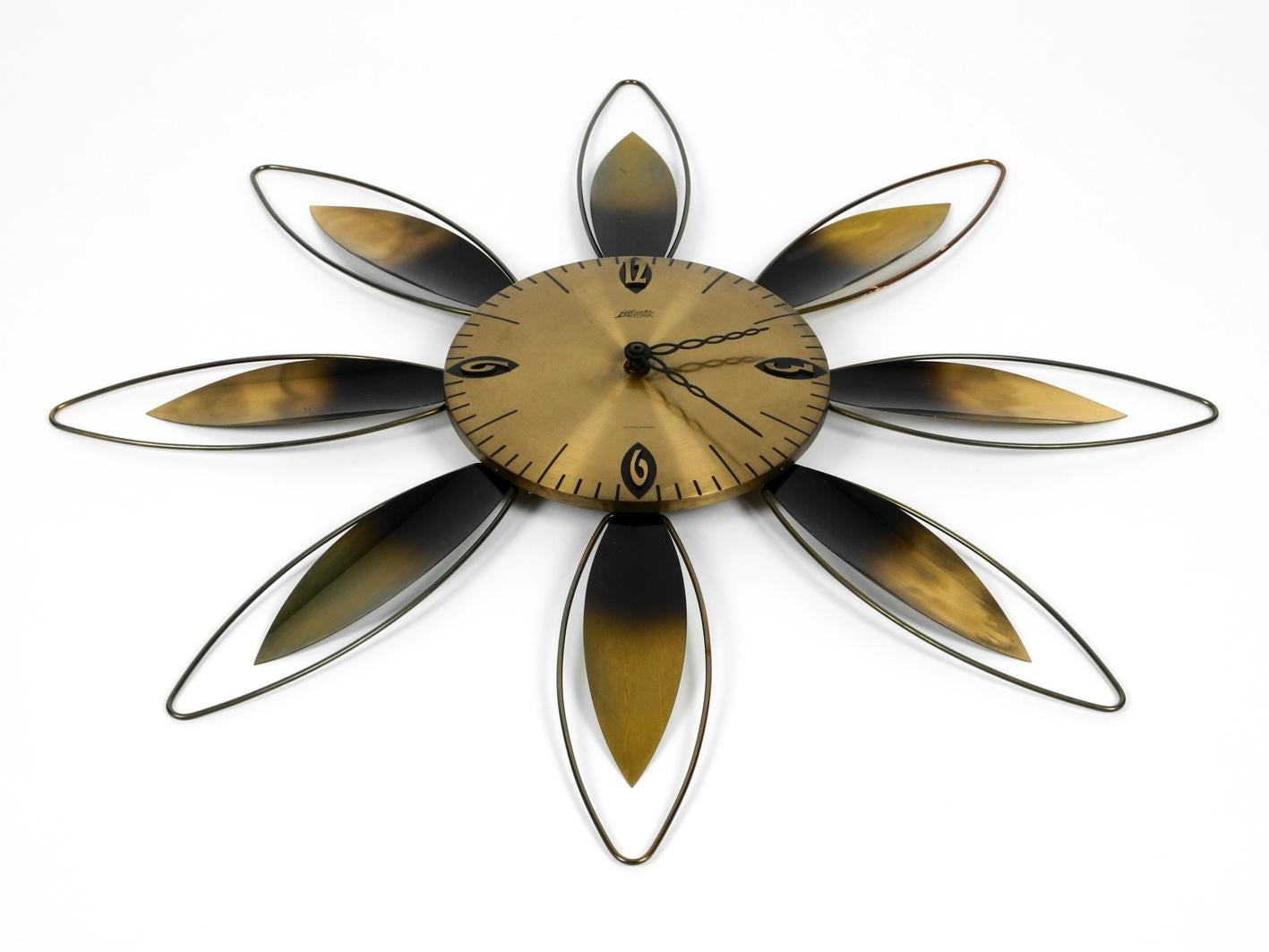 Gorgeous original 1950s Sunburst Atlanta electric wall clock in brass. Made in Germany.
Very nice elaborate midcentury design in the shape of a flower. With a Dugena drive for standard C LR14 batteries. Numerals in typical 50s design. 100% original