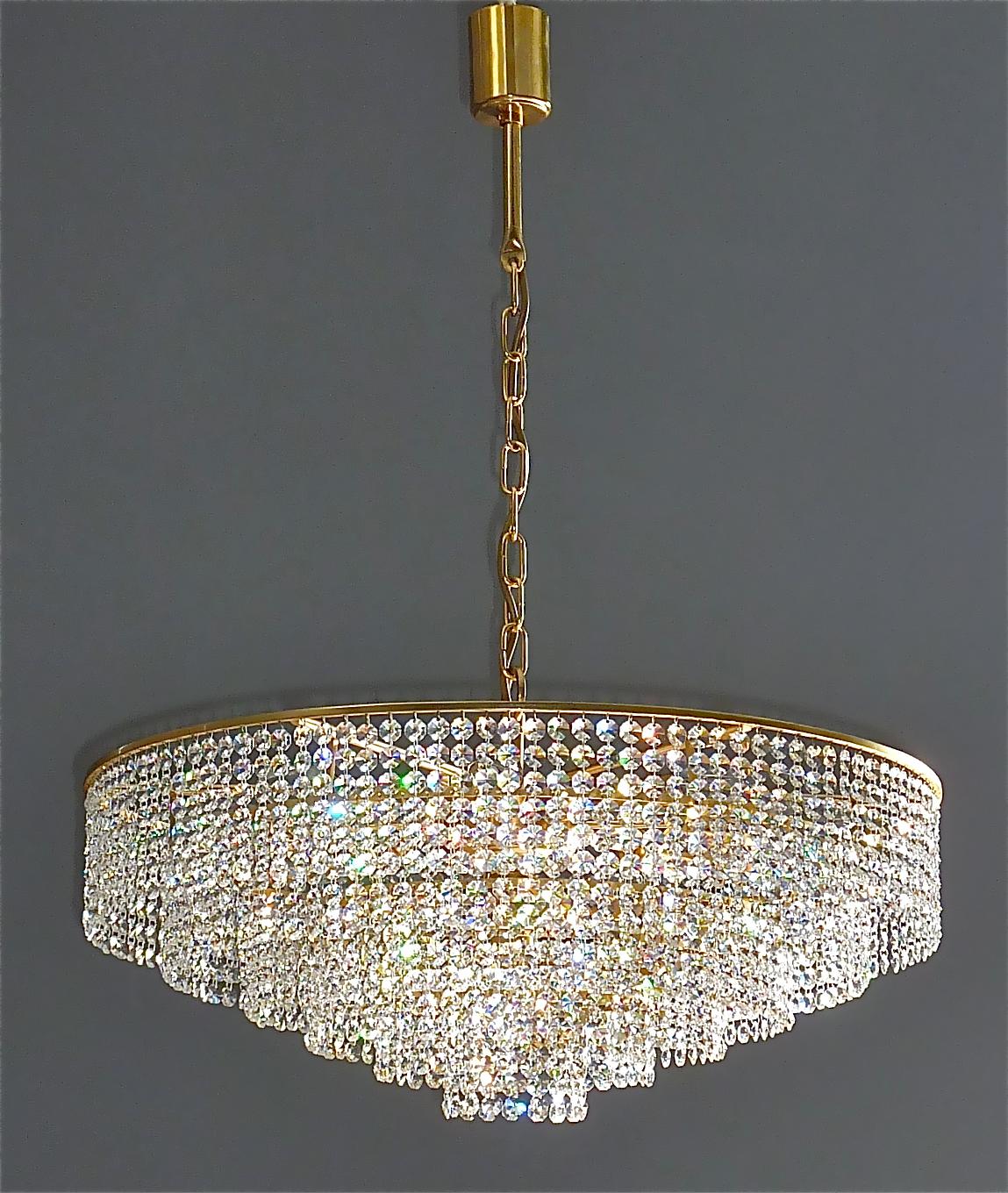 Classic extra large and precious gilt brass and crystal glass chandelier made by high class lighting company Palwa, Germany, circa 1960. The chain-hanging chandelier has 6 cascading tiers with lots of high lead handcut faceted crystal glass strings