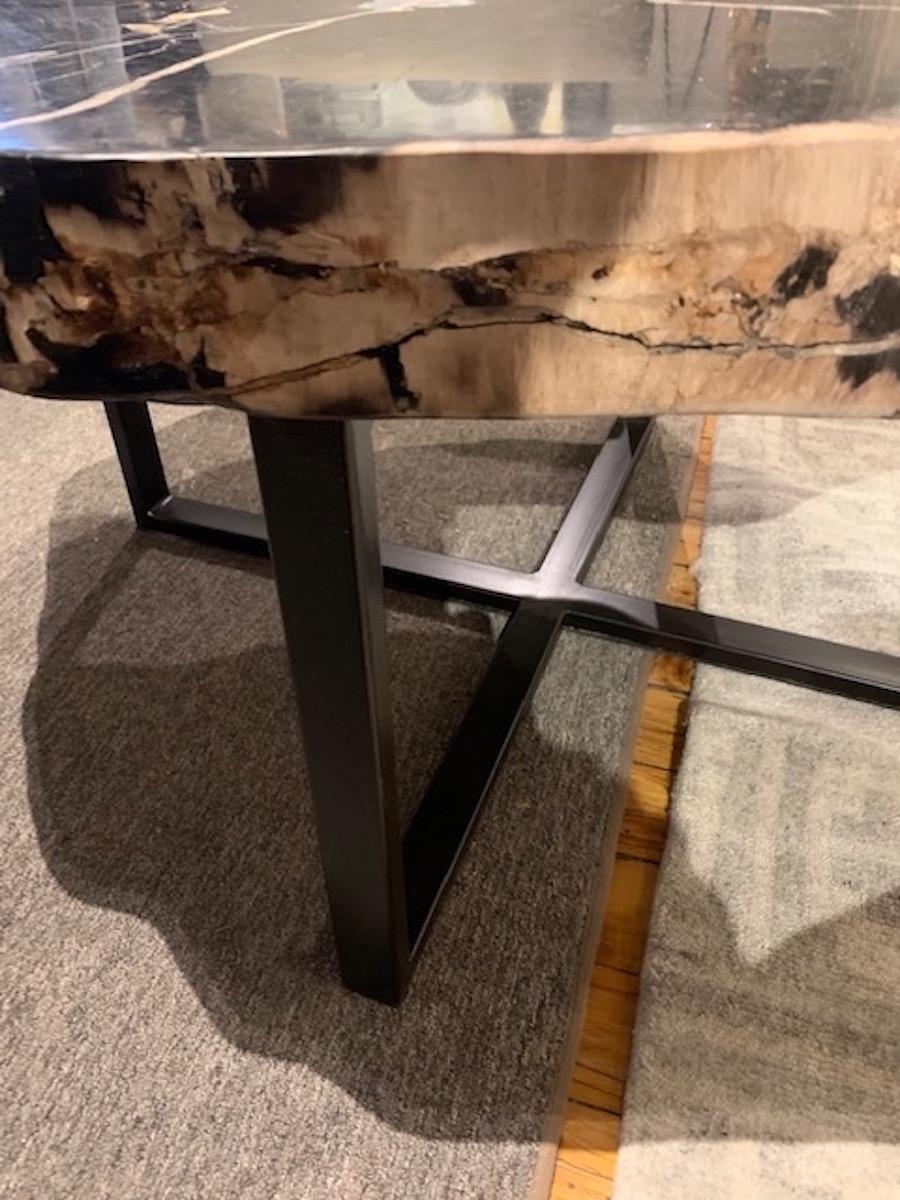 Contemporary Indonesian thick sliced petrified wood coffee table on a black steel cross bar stand.
The black with cream top has a polished finish.
The table is very durable and sturdy
