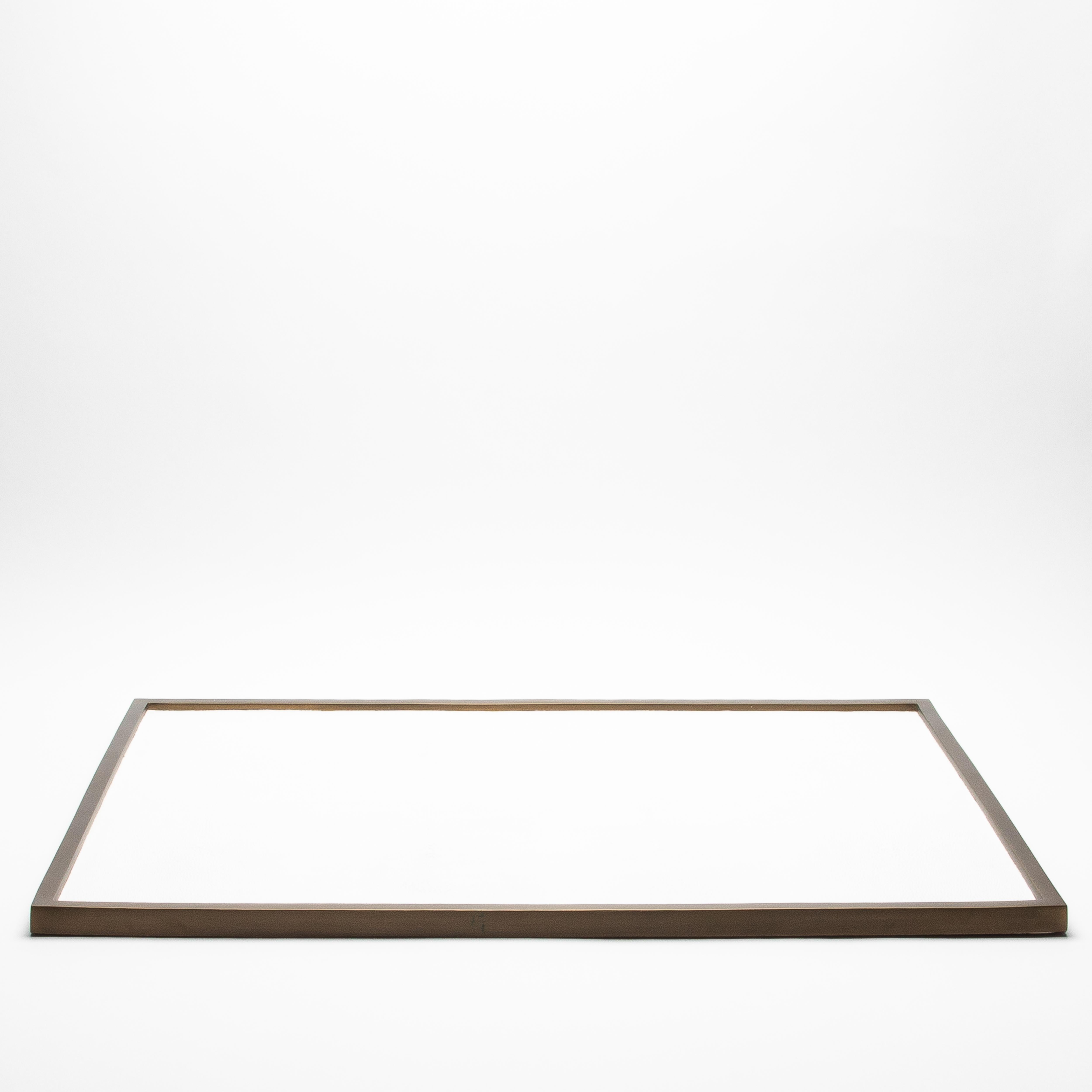 Ce très grand plateau rectangulaire de Kifu Paris présente une luxueuse surface en galuchat blanc encadrée de laiton patiné bronze, créant un contraste raffiné entre la texture et le métal. Mesurant 32 x 24 pouces, son design épuré et minimaliste et