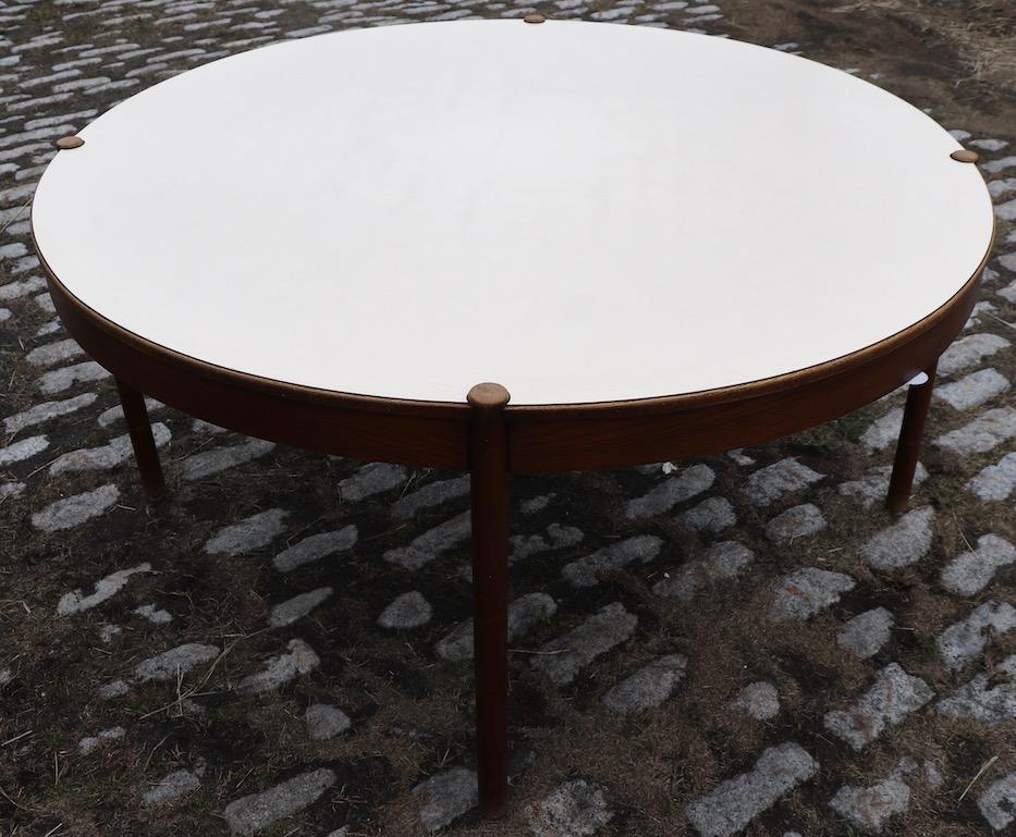 Extra large (60 inch Dia.) architectural design dining, work, conference table. This table has a white Formica top with tapering round legs and wood bib trim. Originally found in a local Community College, it is commercial grade construction, built