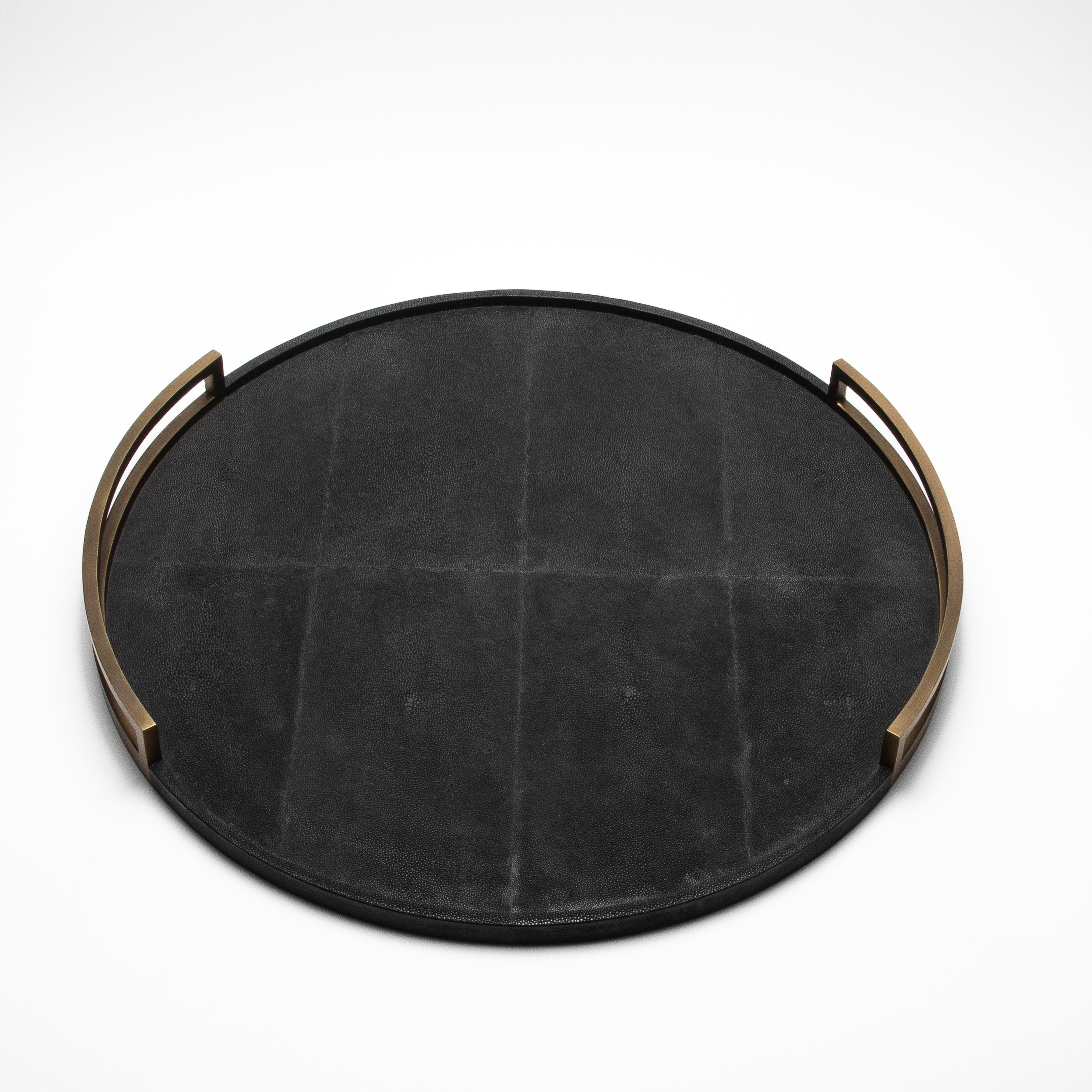 Das runde Tablett Extra Large von R&Y Augousti strahlt Eleganz aus mit seiner luxuriösen Oberfläche aus schwarzem Chagrin, fachmännisch umrahmt von bronzefarbenem patiniertem Messing. Dieses handgefertigte Tablett mit seinen klaren Linien und