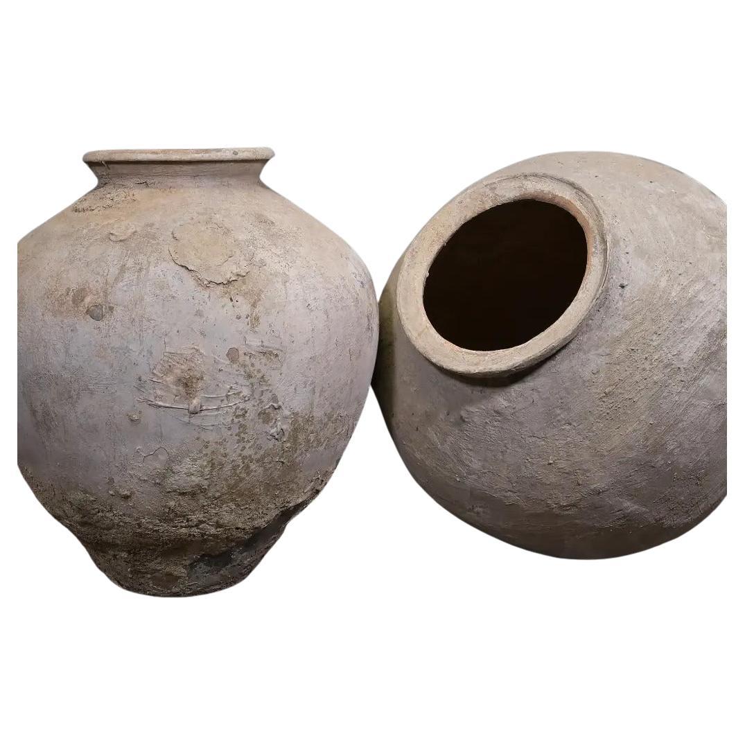 Questo antico vaso per l'acqua proveniente da Giava è un recipiente tradizionale realizzato a mano e utilizzato per conservare cibo o acqua potabile. Realizzato in terracotta naturale, presenta una bella superficie rovinata dagli agenti atmosferici