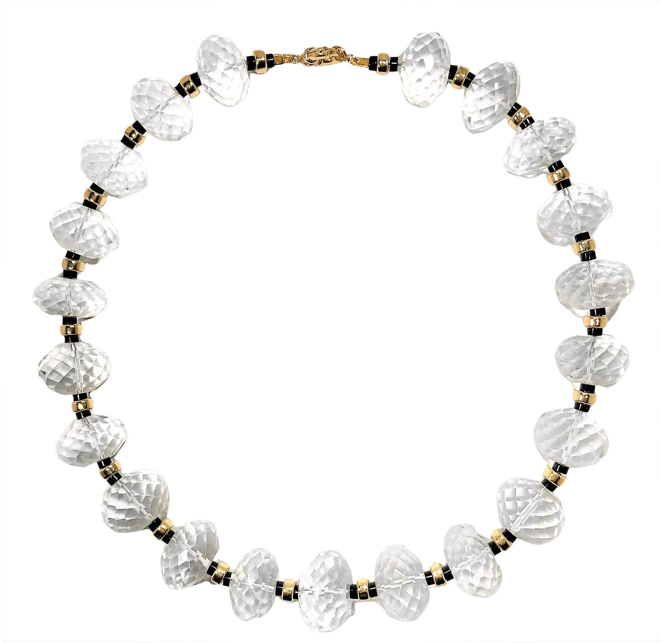 This striking, vintage, natural rock crystal necklace was created on a grand scale. The  twenty one faceted beads measure 24.5mm, on average,  and are separated by one 14K yellow gold roundel, flanked by two black onyx discs. Measures 20.5 inches