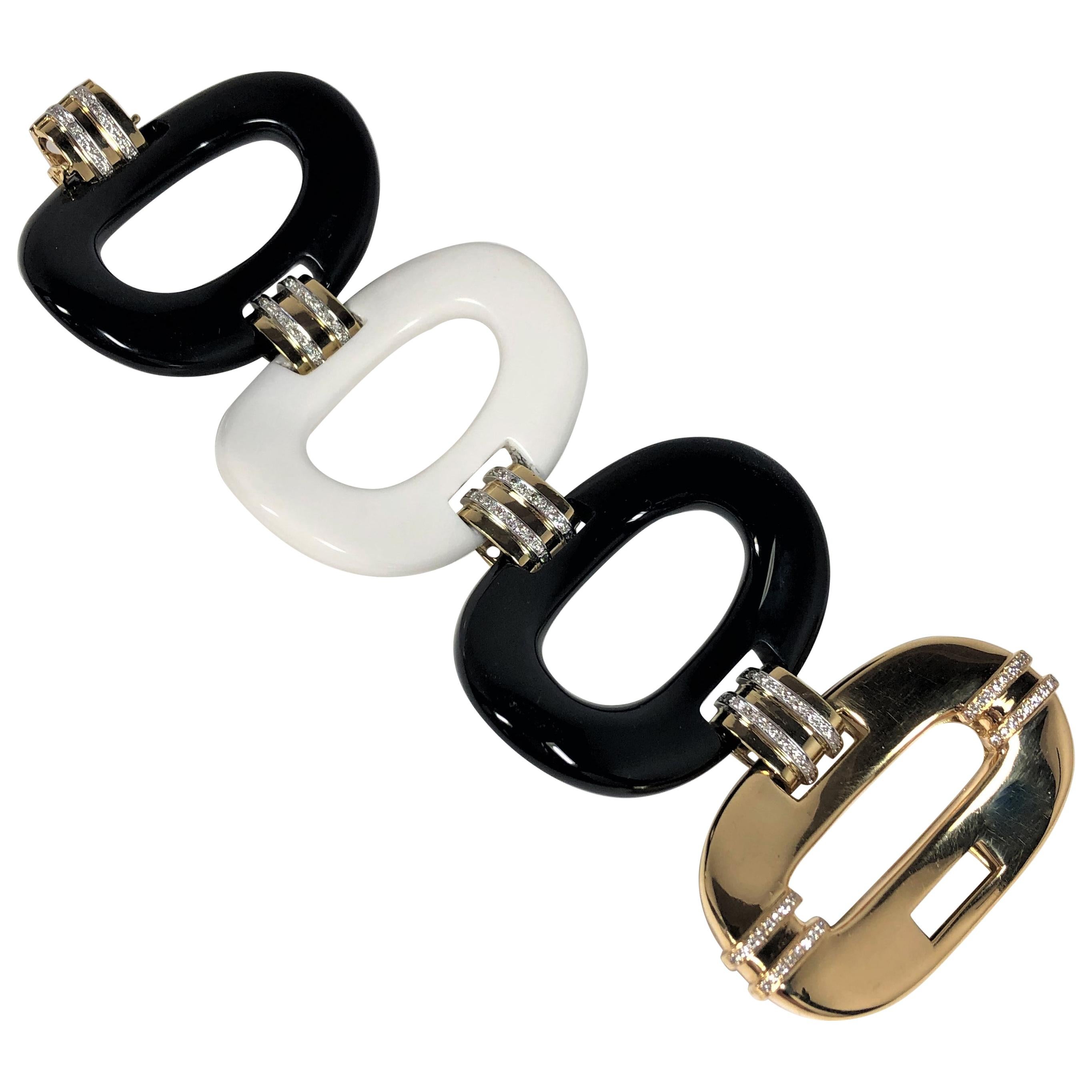 An amazing statement piece of jewelry. Fashioned in 18K Yellow Gold, this extra large scale bracelet is made up of four oval links; one in Gold, one in white porcelain, and two in black porcelain. Each extra large, curved, porcelain link measures 2