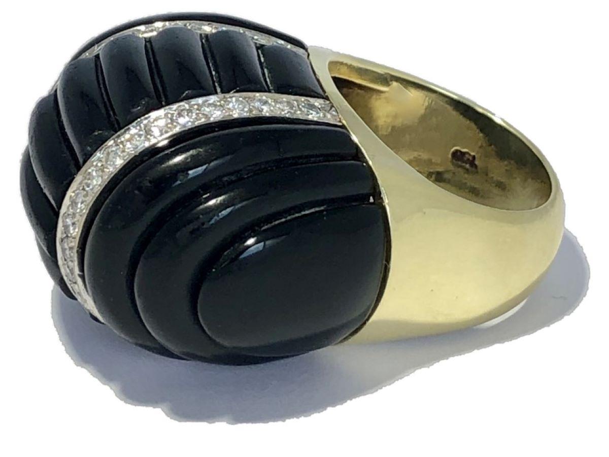 This well detailed, extra large scale cocktail ring was manufactured in 18k yellow gold with a fluted onyx dome center punctuated by two strips of brilliant cut diamonds and fluted onyx shoulders. The 46 diamonds have a total approximate weight of