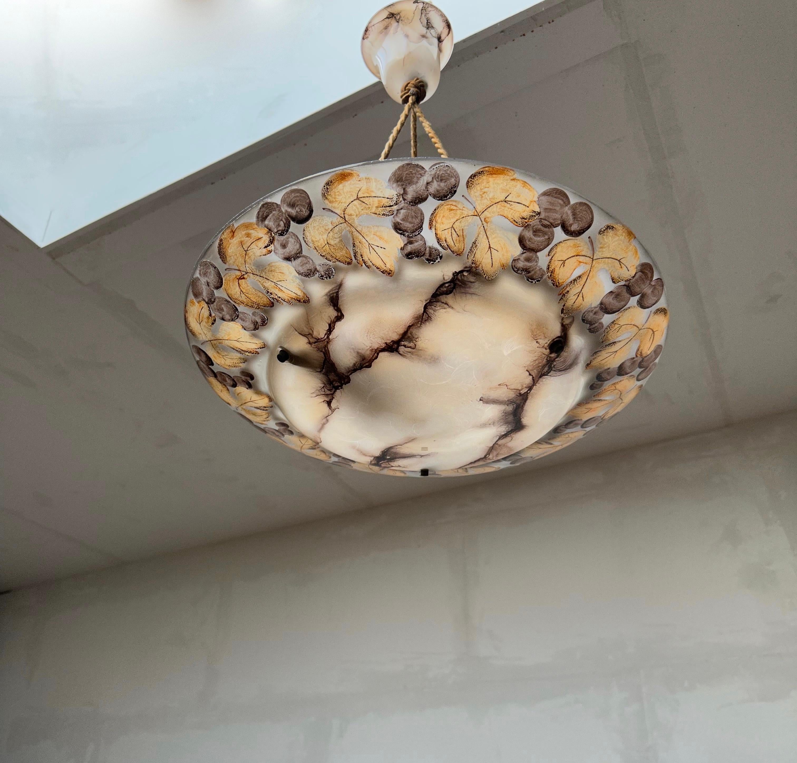 Unique hand crafted Art Deco layered marble-like glass ceiling fixture with the original matching glass canopy.

In our combined 25 years of selling light fixtures we have never before seen one with these beautiful, hand-painted leafs and plum like