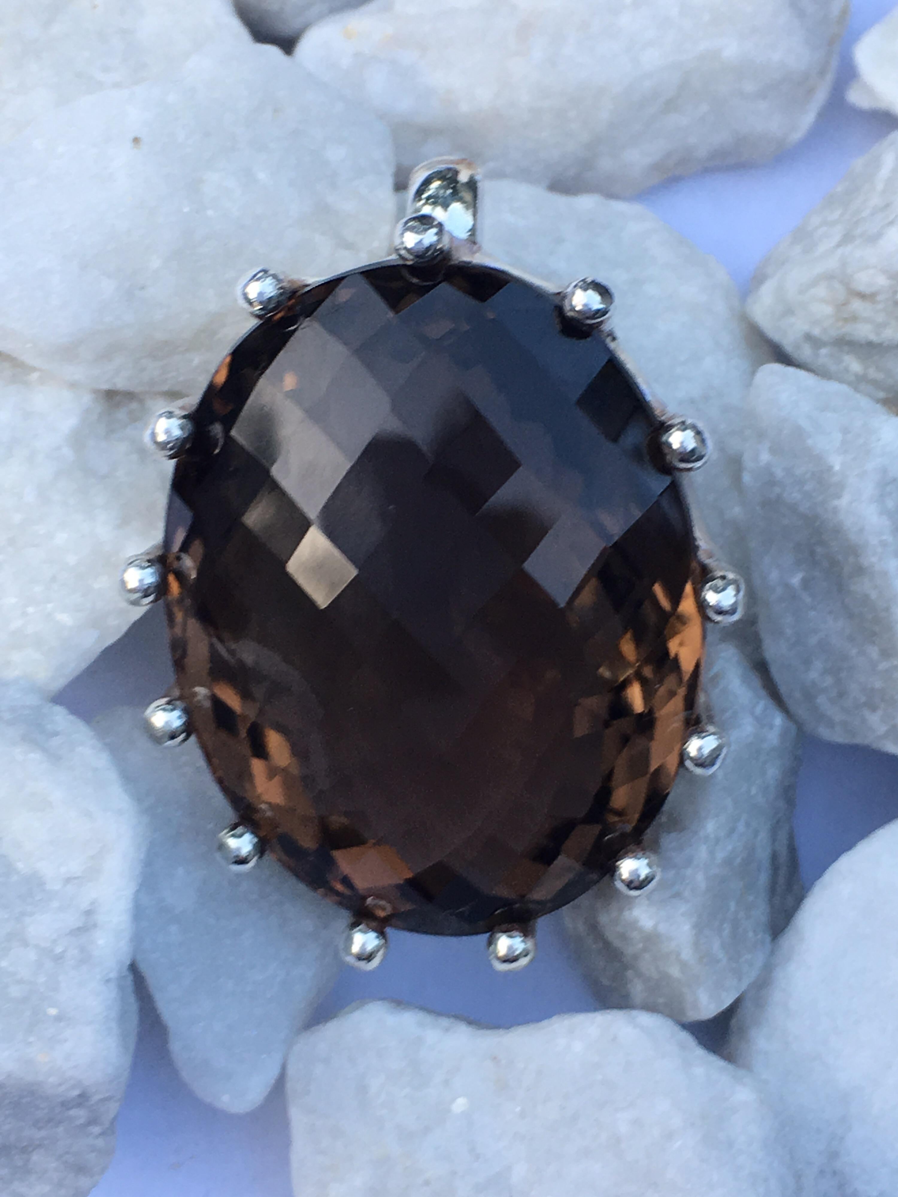 Extra Large approx 50 Carat Smokey Quartz set in sterling silver.
Handcrafted by skilled Silversmith. 
smokey quartz is double cut or checker cut .
Oval stone 22 MM X 27 MM 
One can use this pendant on Leather Band or Silver chain.
