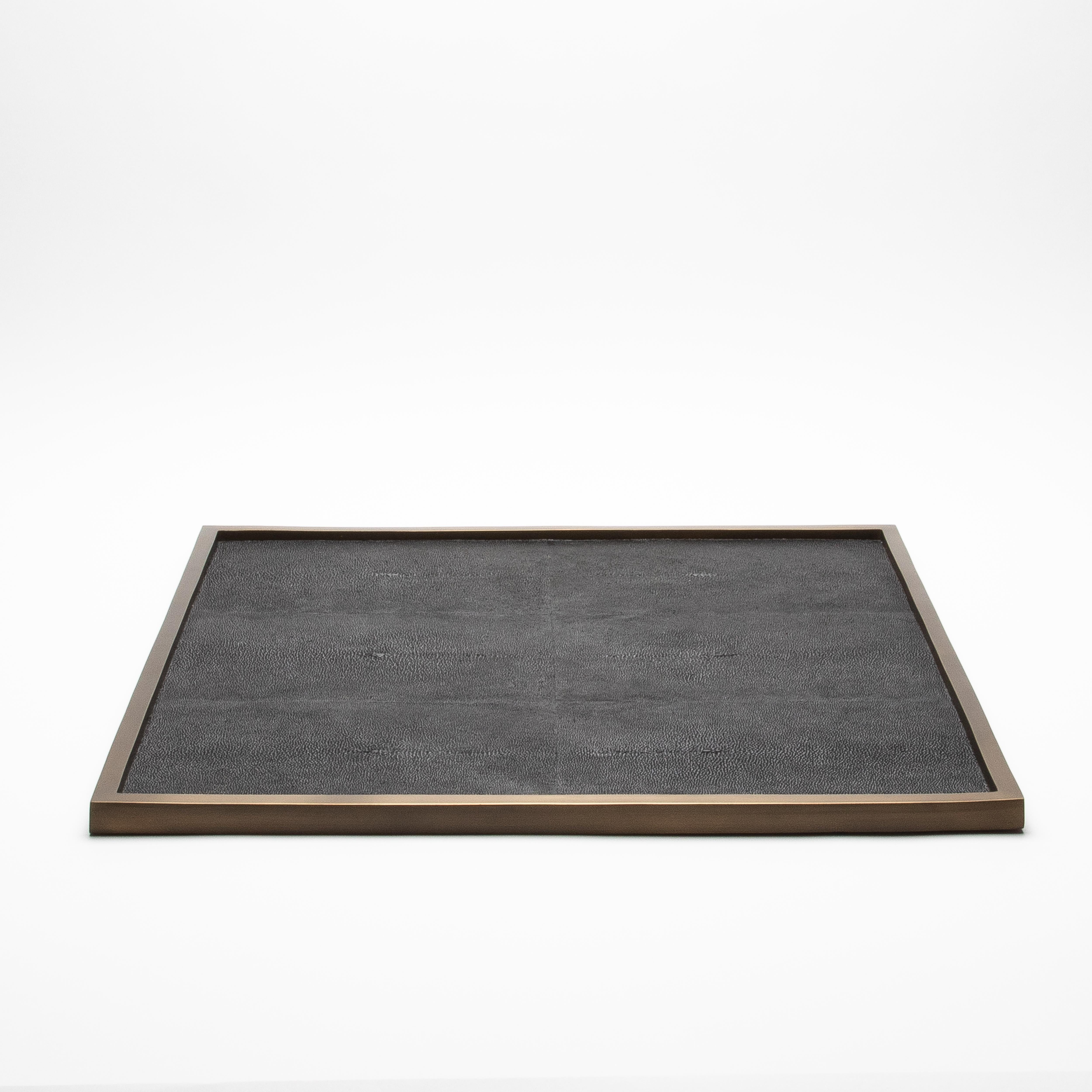 Ce très grand plateau carré de Kifu Paris présente une luxueuse surface en galuchat noir encadrée de laiton patiné bronze, créant un contraste raffiné entre la texture et le métal. Mesurant 30 pouces de chaque côté, son design épuré et minimaliste