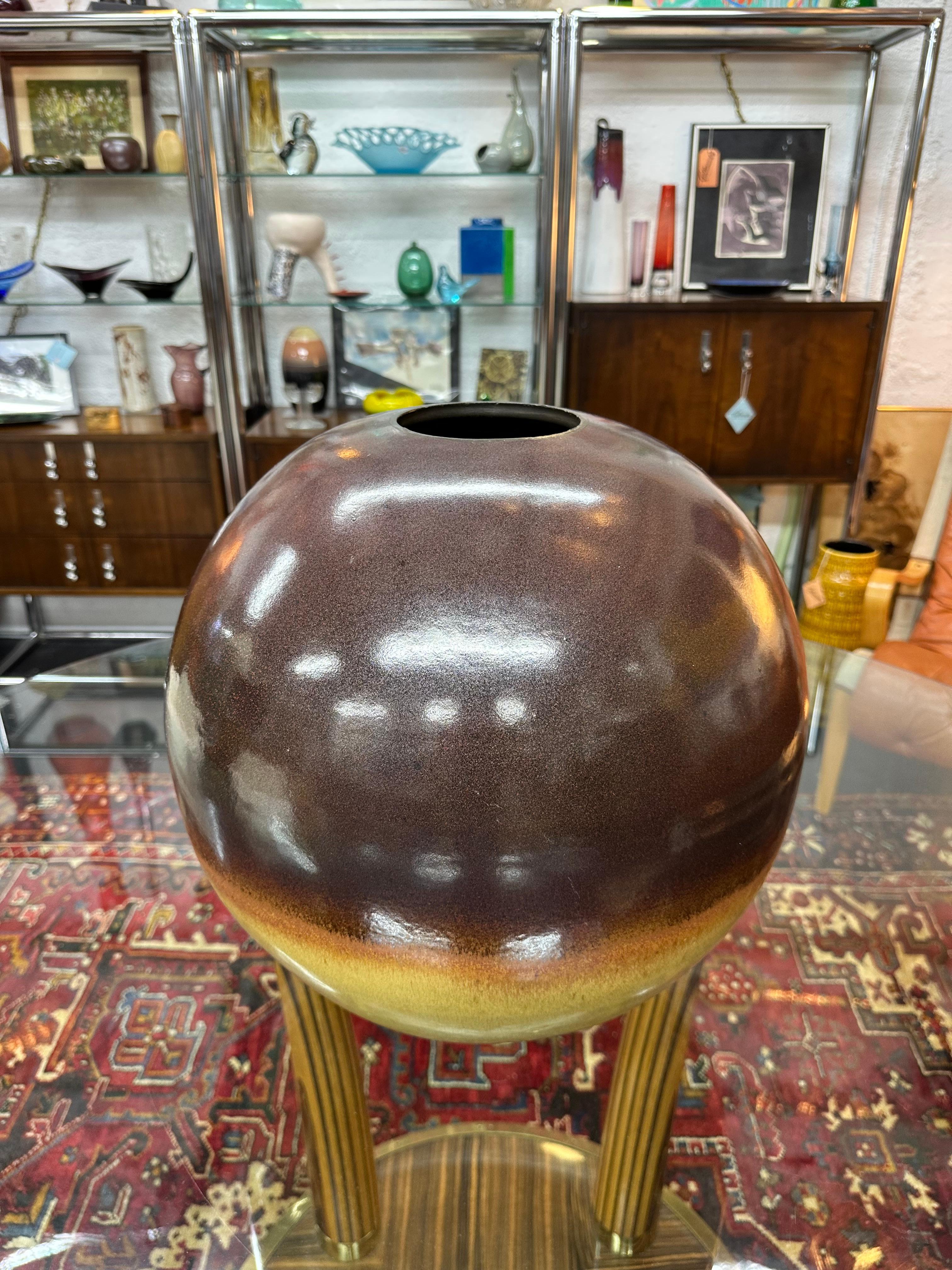 Large impressive studio pottery ball vase in brown, orange and yellowish tan glaze. A substantial piece measuring 17”H x 17”W/D. Great vintage condition, no chips or cracks. Signed on bottom Perkins 1995.

This large piece is water tight and would