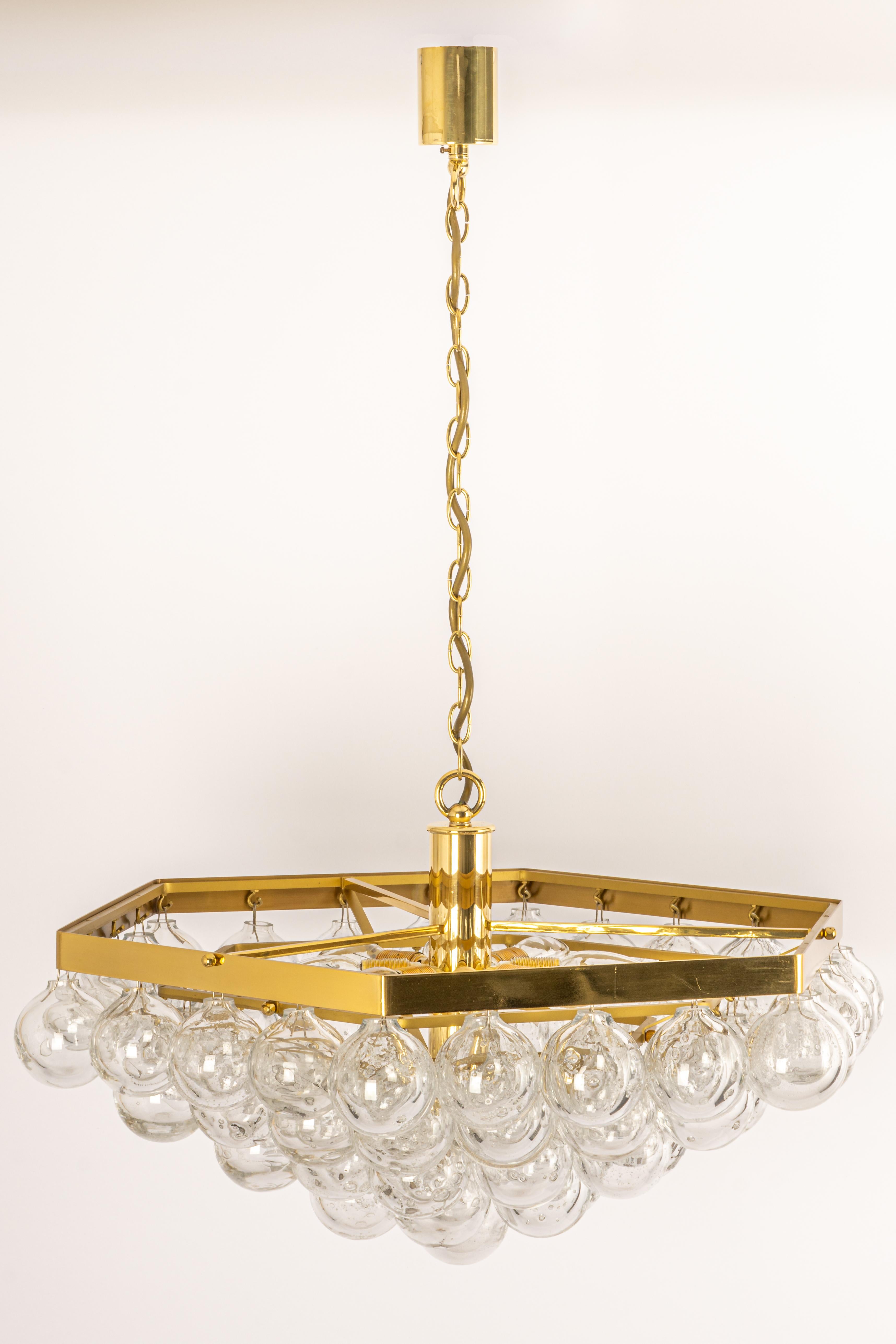 Wonderful onion-shaped -Tulipan glass chandelier. 61 hand-blown glasses suspended on a brass metal frame.
Best of design from the 1960s by Kaiser Leuchten, Germany. High quality of the materials.

Sockets: The chandelier takes 8 small screw base