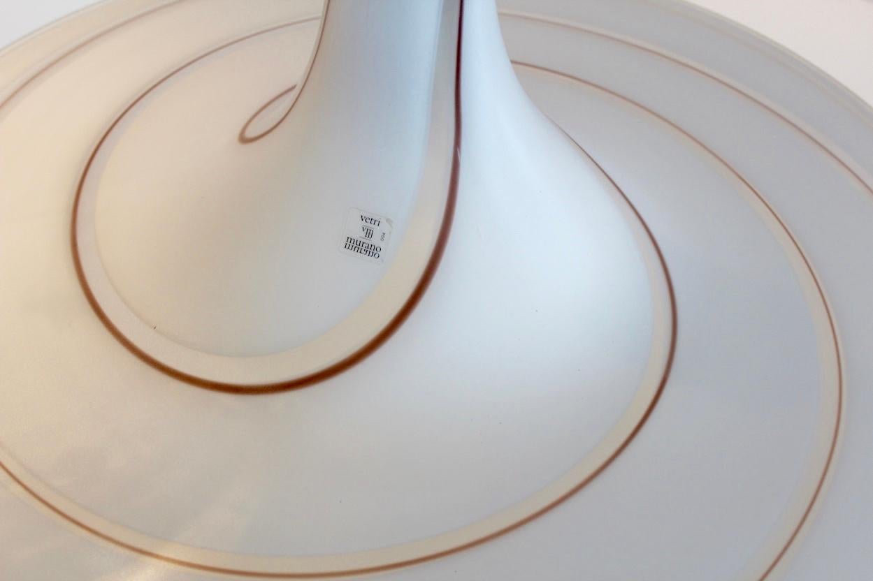 Eleganter und großer italienischer Anhänger von Vetri Murano. Handgeblasenes Glas in Opalweiß mit klaren und gold-braunen Strudeln im Glas. Mit dem originalen Label, der verchromten Kappe und dem Endstück. Diese schöne Murano-Hängeleuchte sorgt für