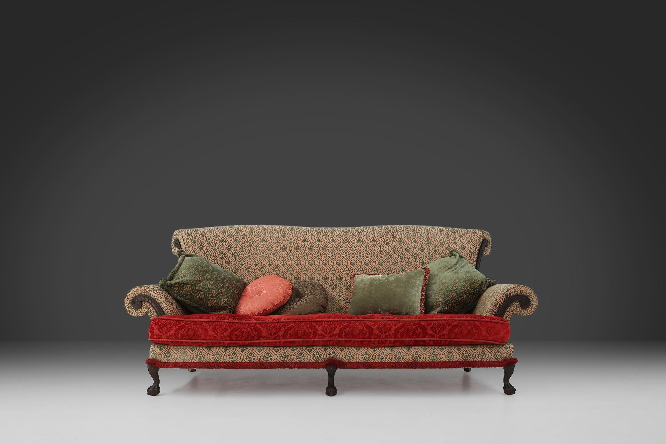 Ce grand canapé victorien datant de 1890 est doté d'une assise confortable et profonde qui vous permet de vous détendre. L'assise est en bois massif et possède d'élégants pieds griffes et boules, qui lui confèrent une allure classique. Le tissu du