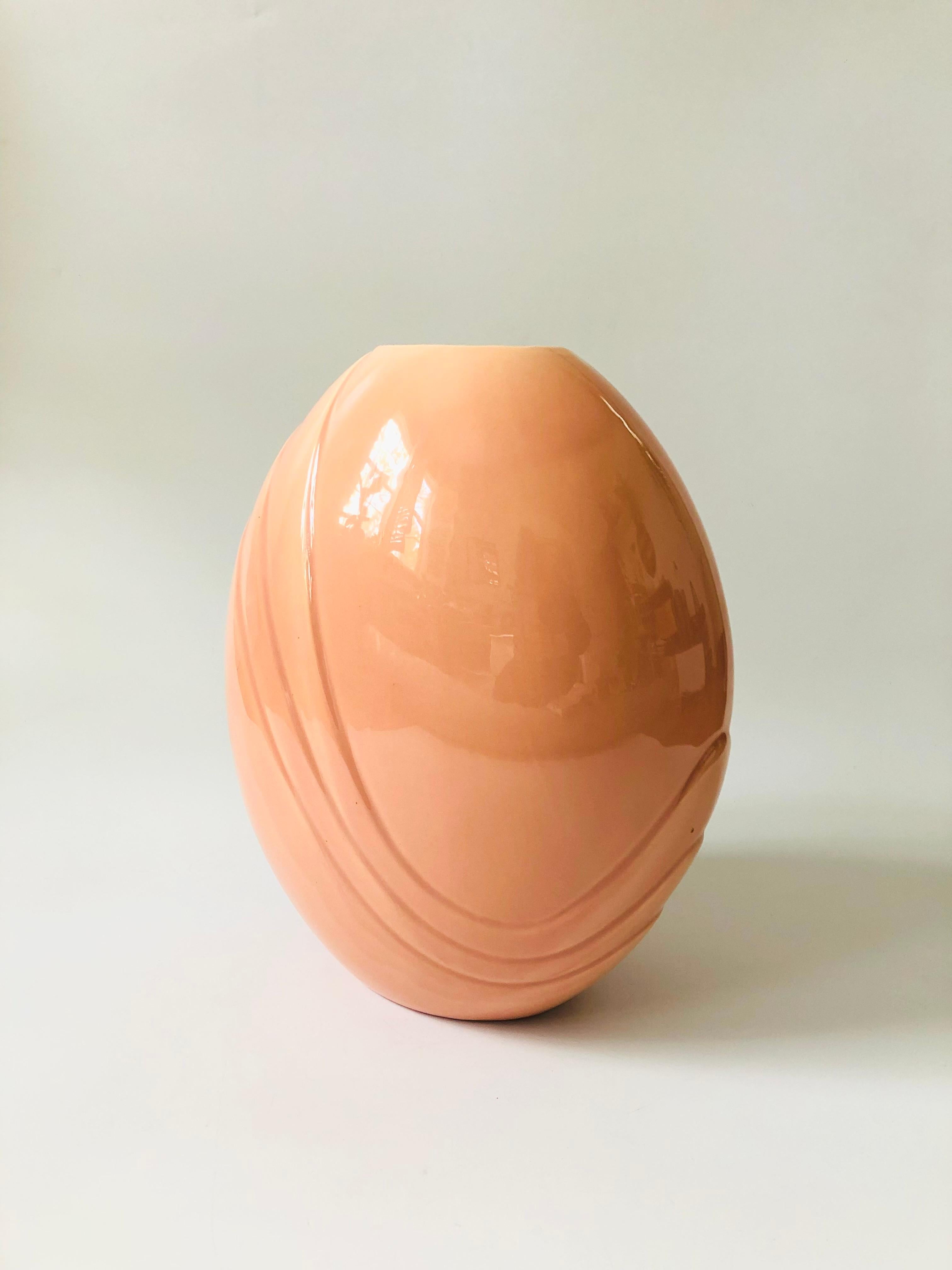 An extra large vintage 80s modern ceramic vase. Nice tapered oval shape with an embossed design on each side. Glossy pink glaze. A sculptural postmodern accent piece.
  