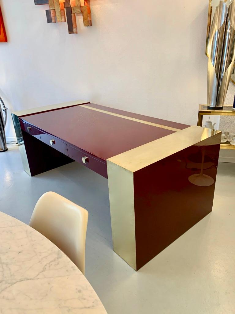 Impressive extra large vintage burgundy red lacquered wood and brass presidential desk by Jean Claude Mahey, France ca. 1970s
Rare in these dimensions.
Signed with brass label on the bottom of one base.
3 front drawers with brass handles.
Brass