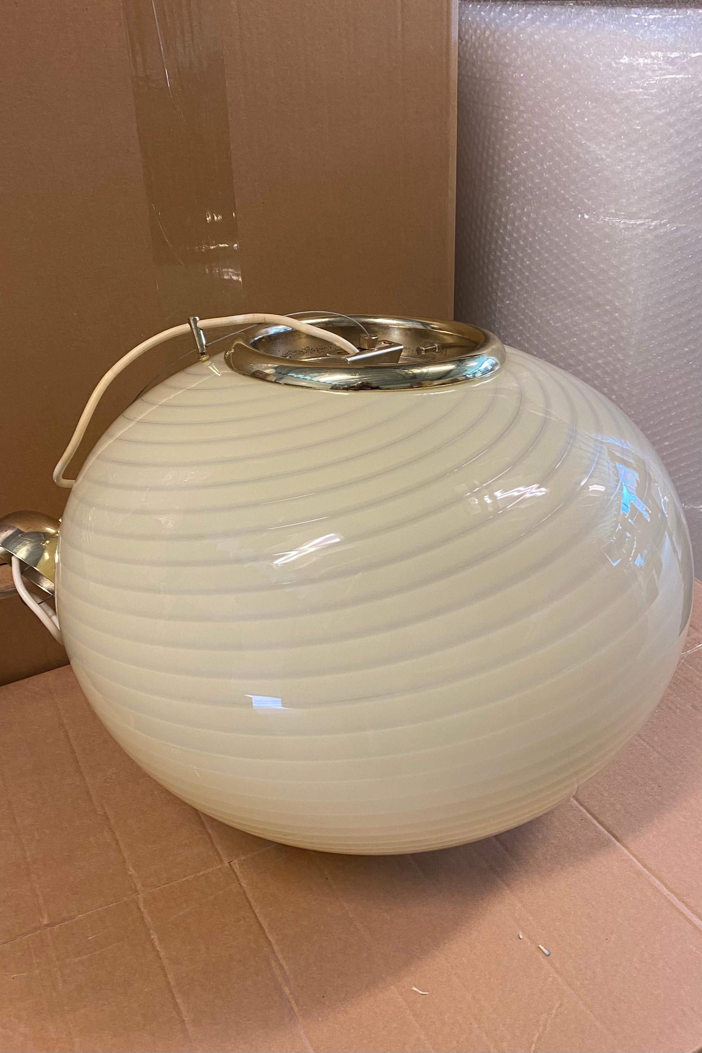 Large vintage Murano pendant ceiling lamp in cream glass. The glass is mouth-blown in an oval shape with a beautiful swirl pattern. Handmade in Italy, 1970s, and comes with original adjustable brass plated suspension. 
'D: 45 cm