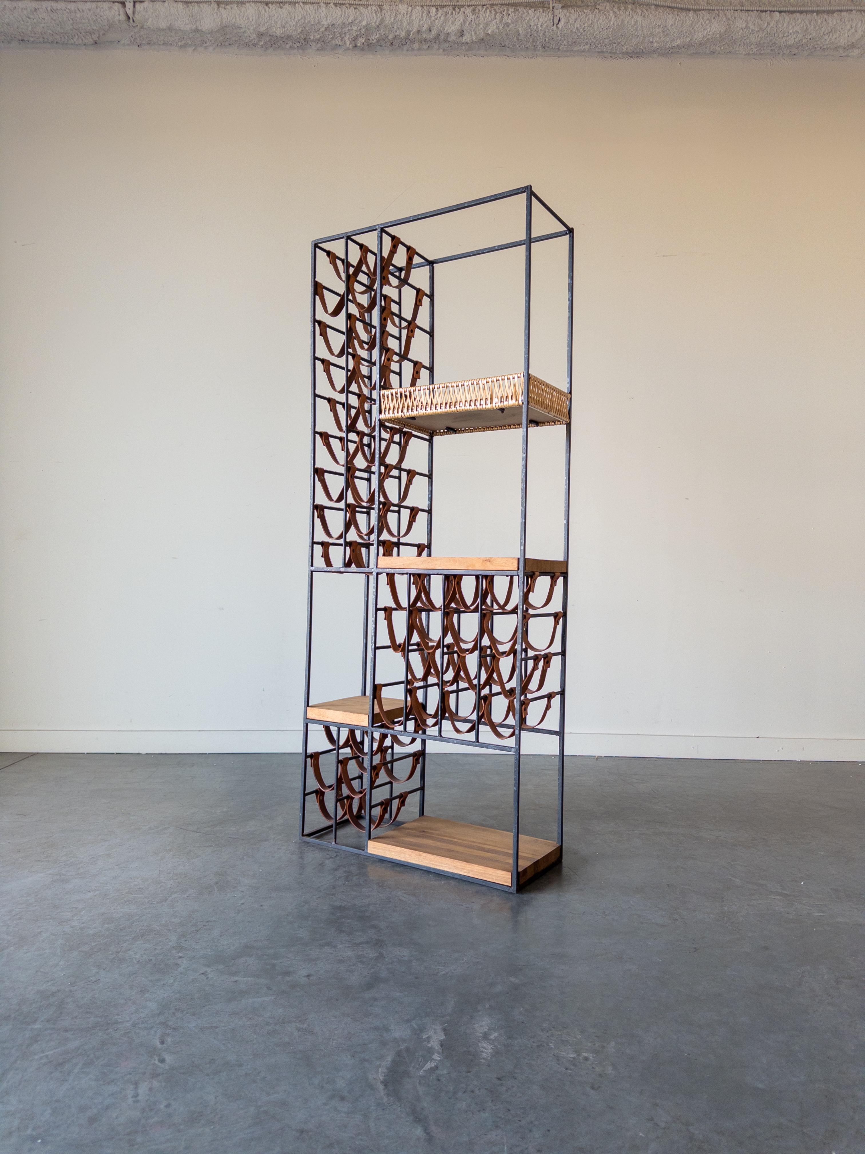 Extra Large Wine Rack with Shelving designed by Arthur Umanoff and manufactured for Shaver Howard in the 1960s.
The solid iron frame supports three wooden shelves and one laminate basket woven with nylon. The rack was designed to accommodate 40