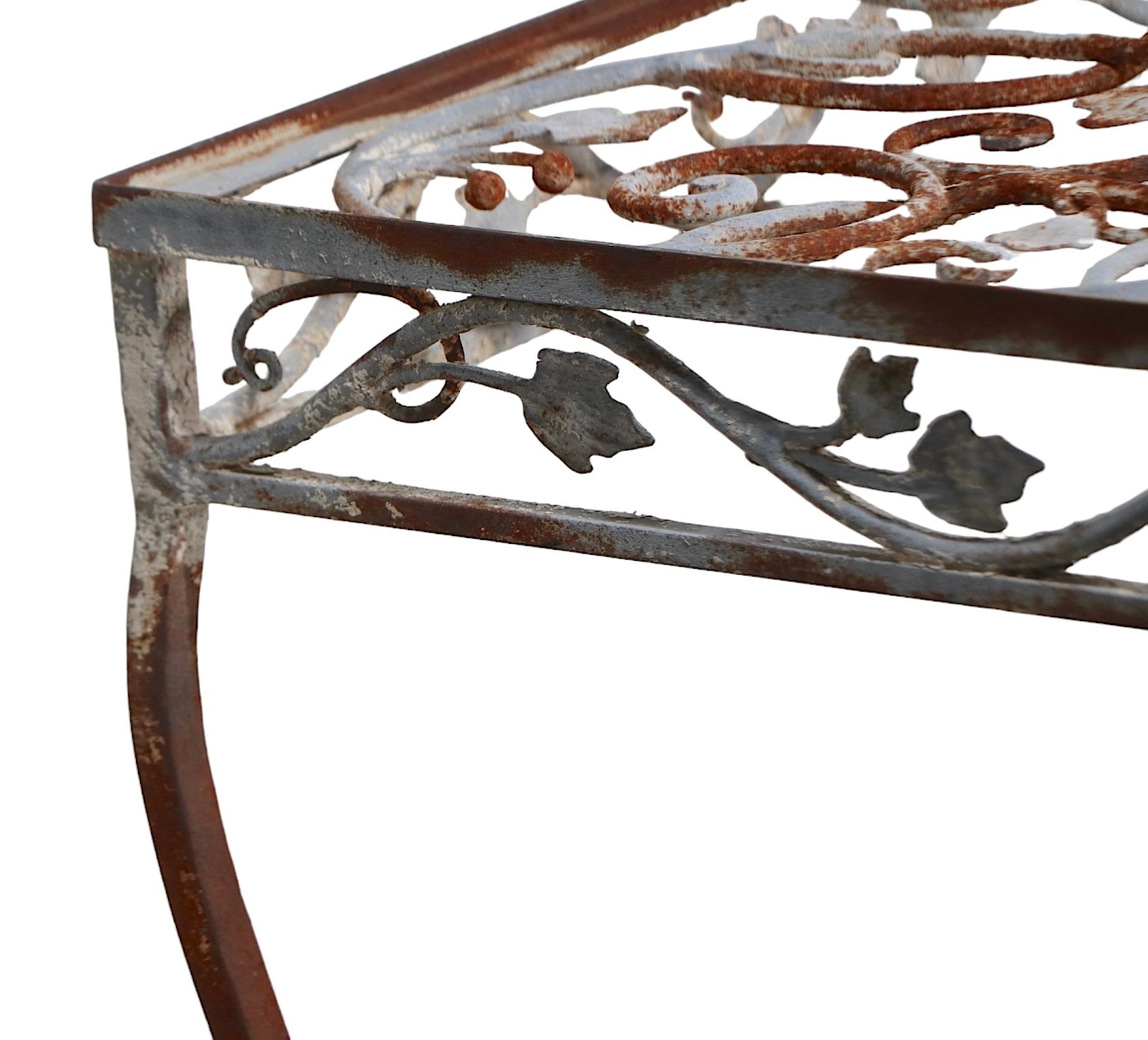 Exquisite wrought iron garden, patio, poolside  dining table by Salterini. The table features  intricate and  finely detailed foliate design metal work, it is in very good, original condition showing cosmetic wear, and light rust, normal and