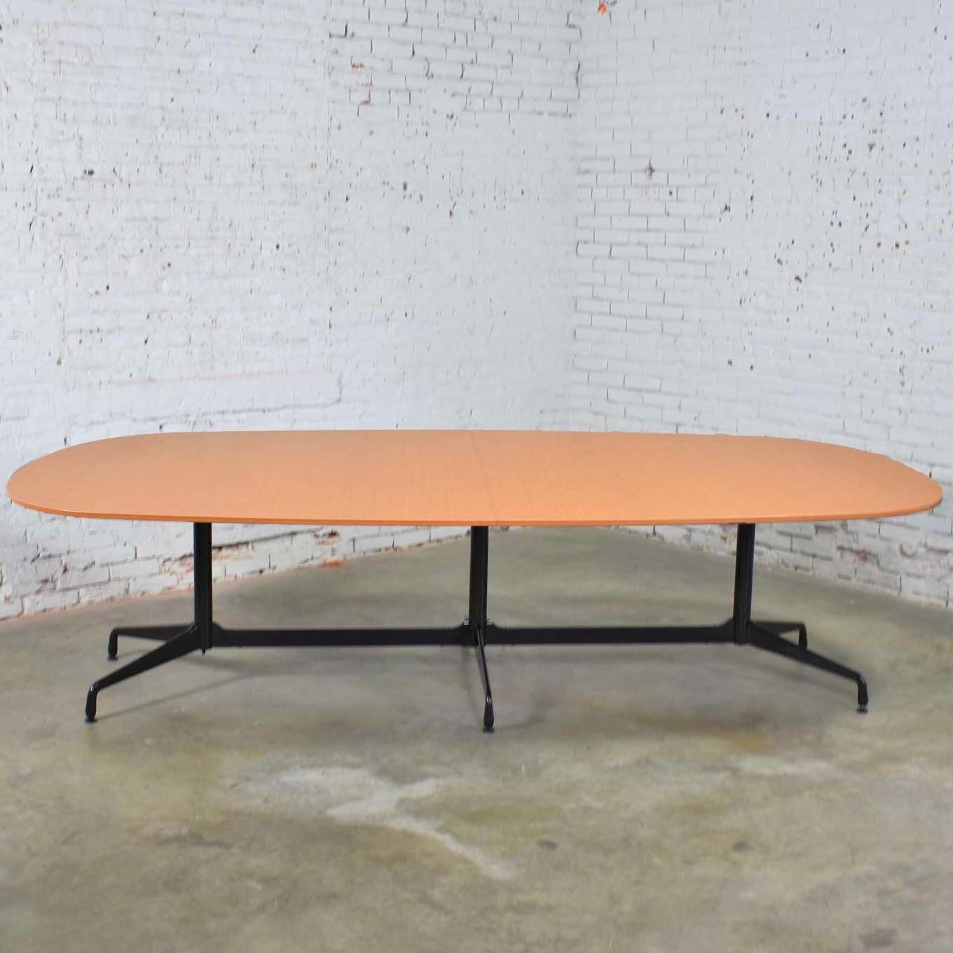 Handsome and iconic elliptical segmented base dining or conference table designed by Charles and Ray Eames for Herman Miller. This one is 120 inches long with a center leg and has a cherry-look laminate top. It is in fabulous vintage condition with