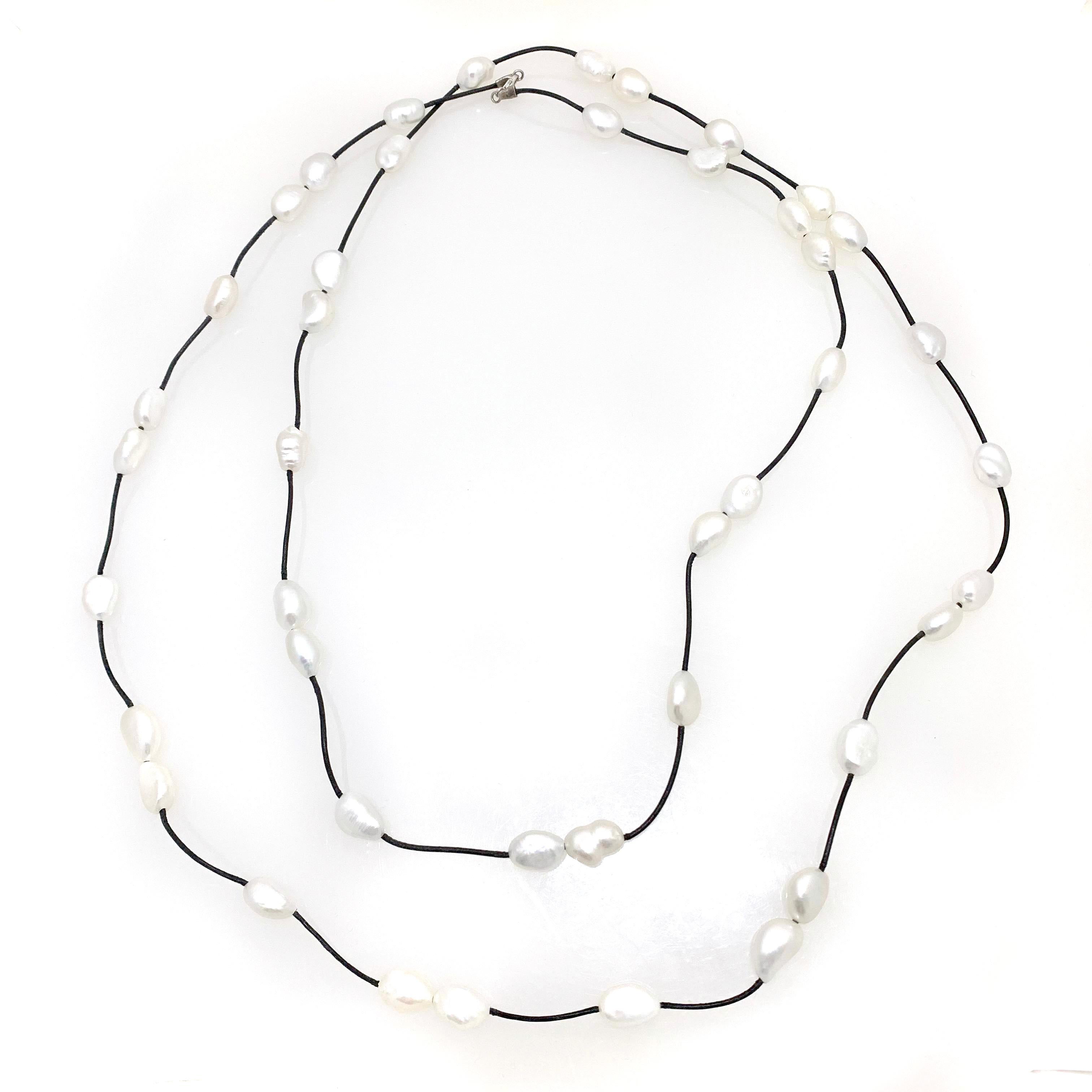 Super chic extra long cultured pearl on leather necklace. 

This necklace features 43 pieces of high luster white cultured pearls strung on black leather cord and closured with sterling silver clasp. The necklace is measured 60