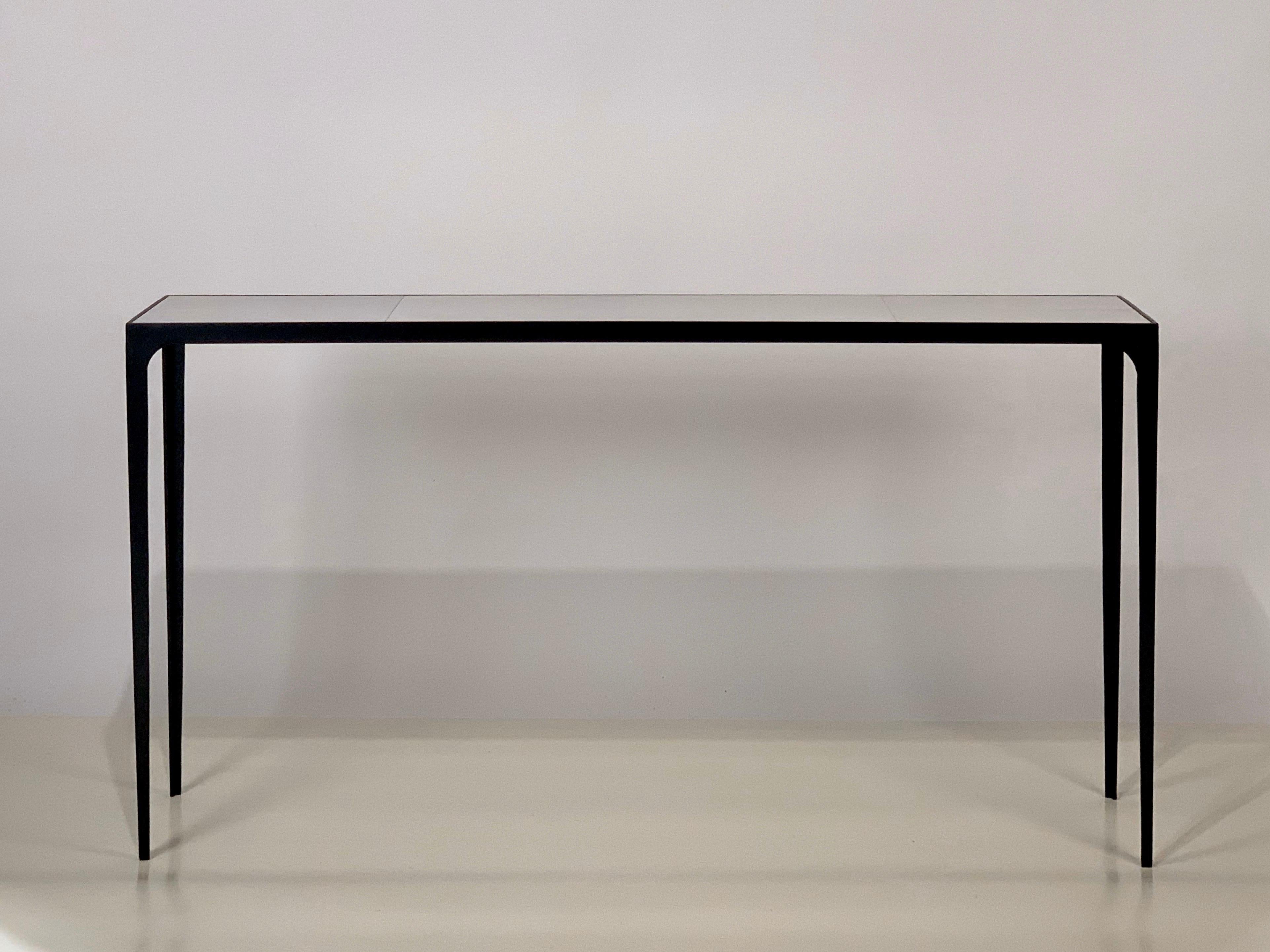 Consolle extra-lunga 'Esquisse' della nostra linea Exclusive Design Frères.

Un'elegante combinazione di una sottile base in ferro annerito con un piano rivestito in pelle di capra (parchemina). 

Proporzioni impressionanti. Eleganza discreta.