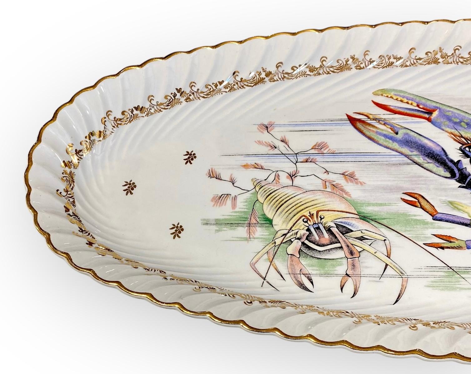 Una fuente de marisco de porcelana francesa vintage extra larga. Fuente para servir pescado, de lados profundos, para poder servir el pescado con salsas y aderezos, sin riesgo de que se derrame.
El motivo es la ilustración más detallada de una rara