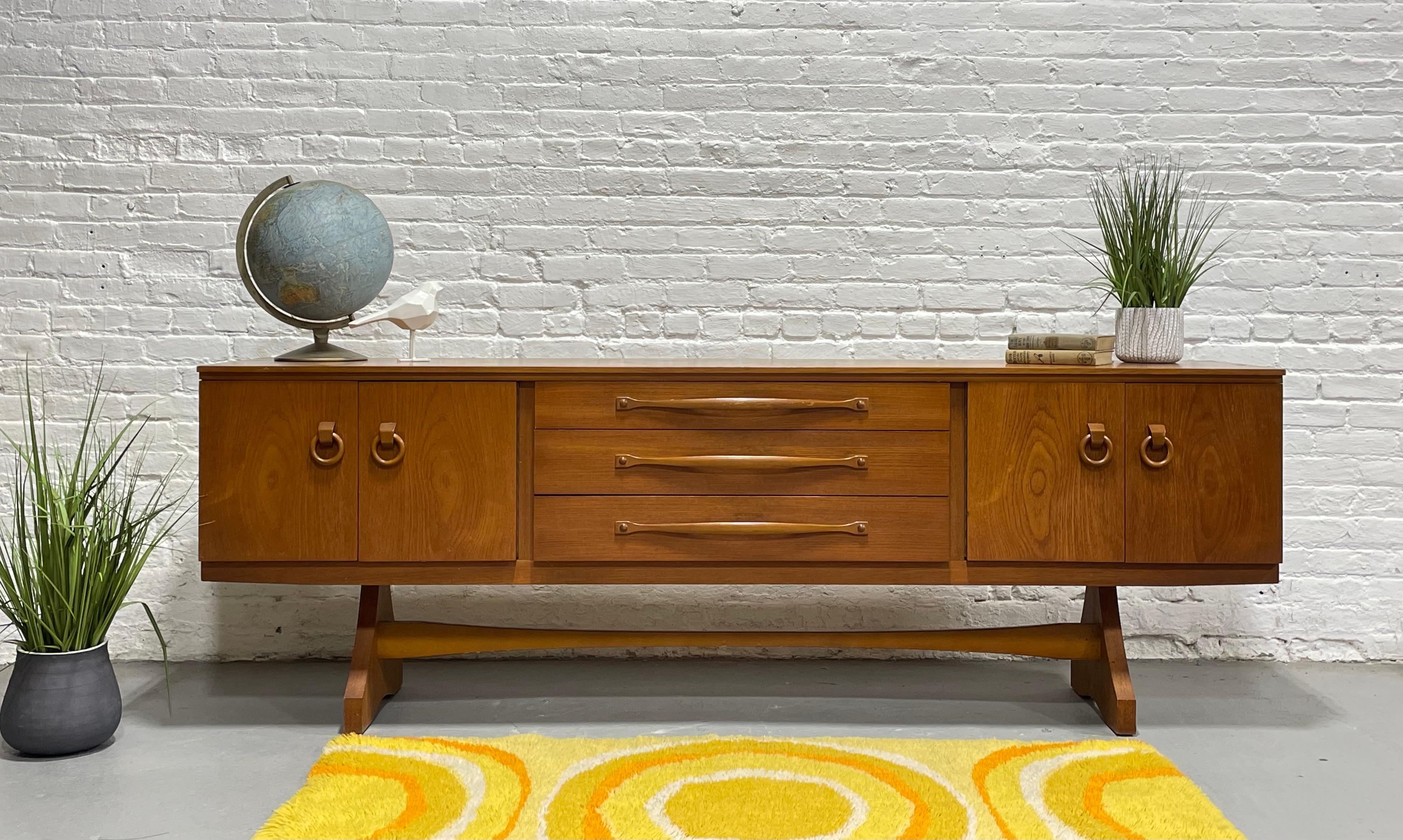 Extra Long Mid Century Modern Danish Teak Credenza / Media Stand, c. 1960's. This sideboard features tons of delicious design details such as round door-knocker style wooden hand-pulls, funky legs and base and plenty of storage space in the two side