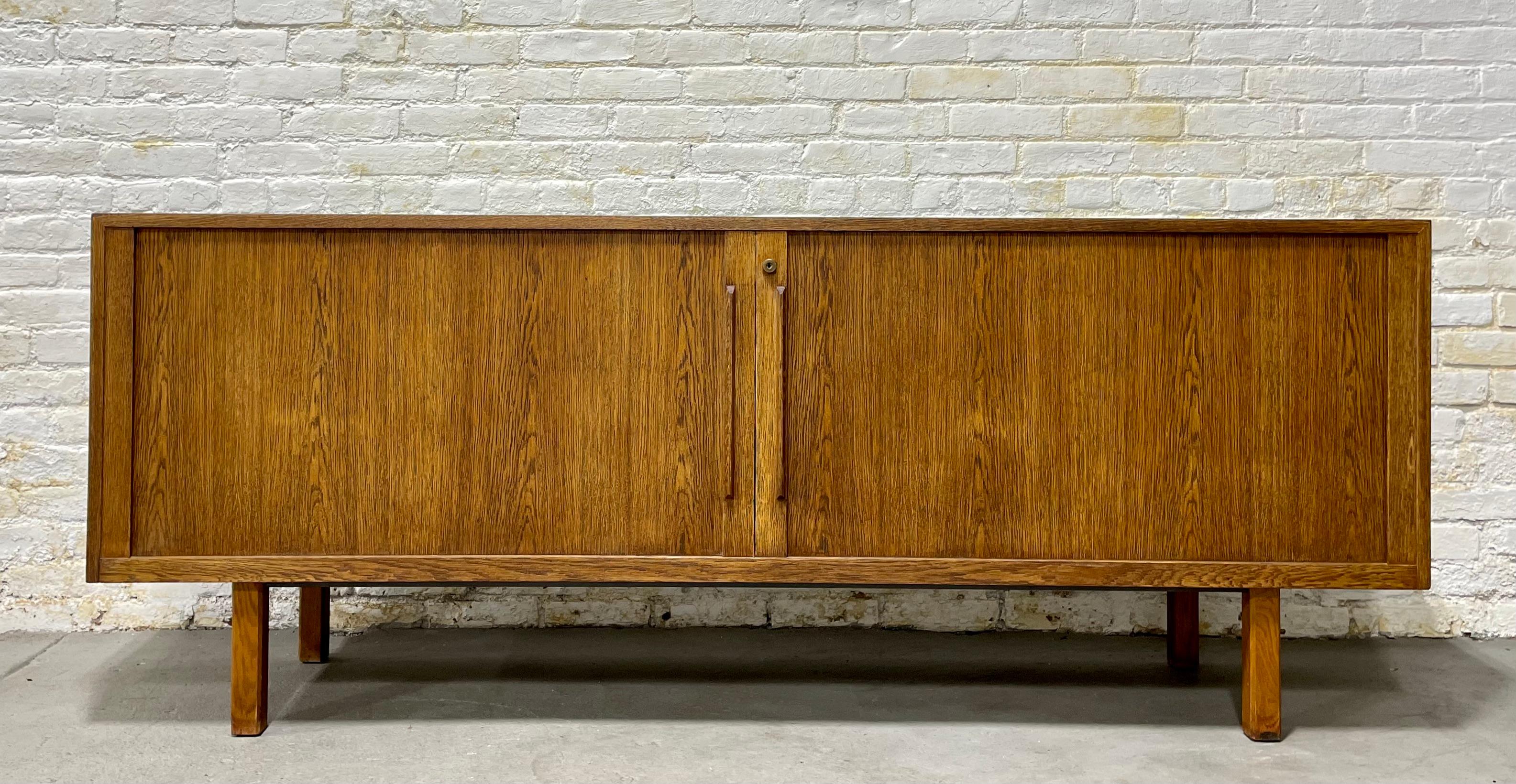 Extra Long Mid-Century Modern Oak Tambour Door Credenza / Media stand, circa 1960s. This monumental piece is gorgeous in its simple yet extremely functional design. Tambour door credenzas are usually found in teak but this beauty is made from oak