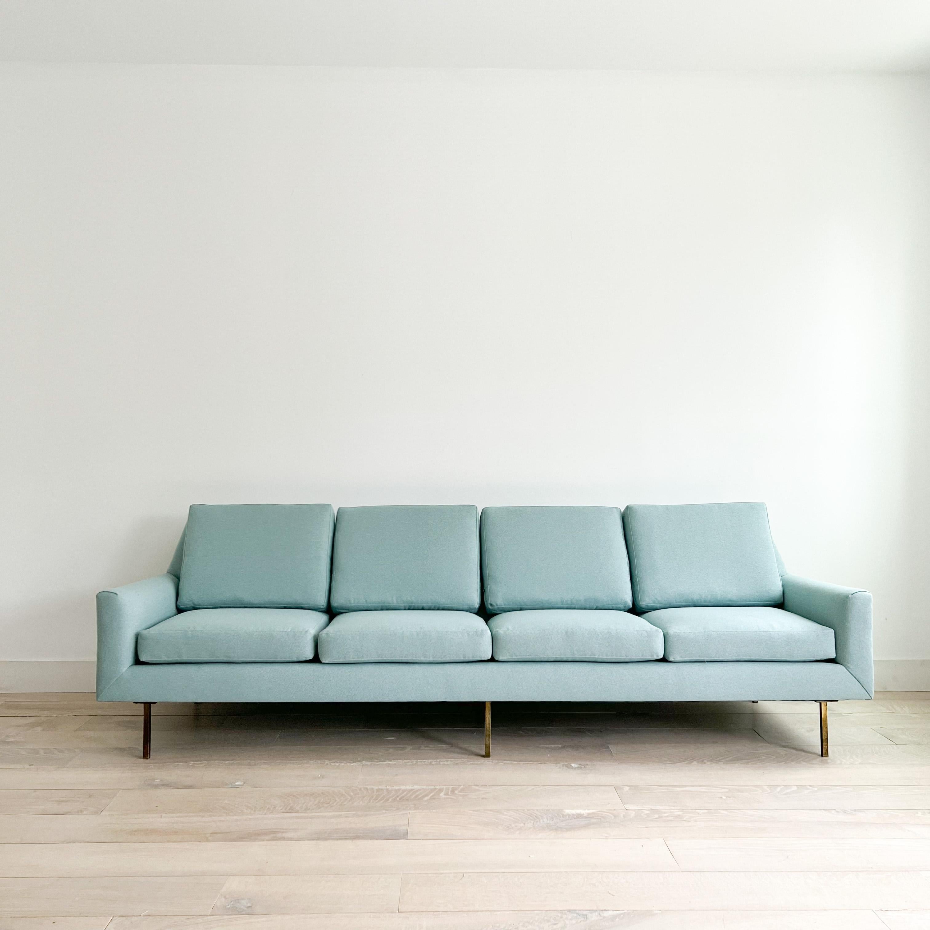 Mid-Century Modern long four seater sofa on brass legs. New foam and light blue upholstery. Some patina to the legs from age appropriate wear. 

Masures: 105”x34” 18”SH 33”H.