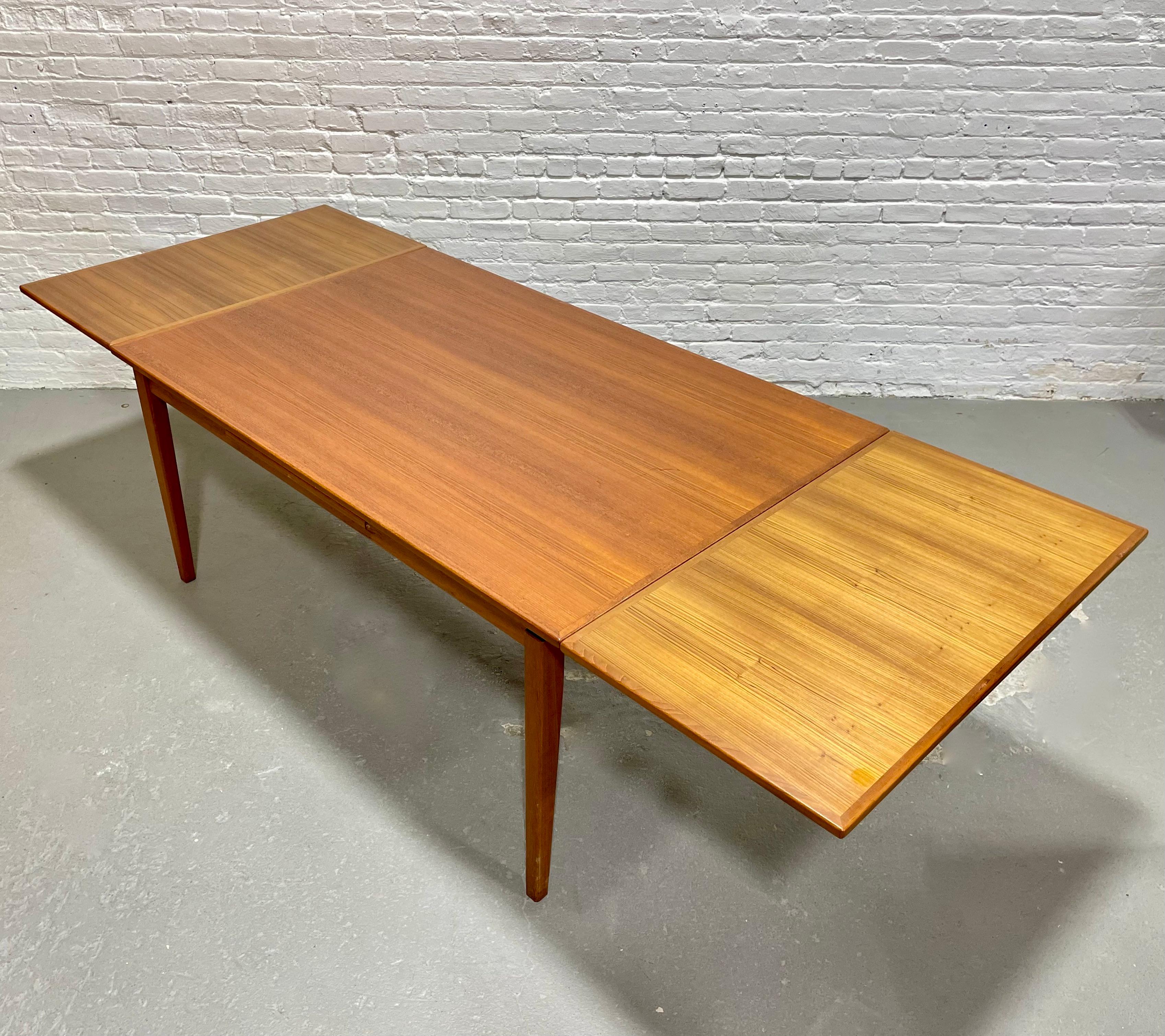 Extra Long Mid Century Modern Expandable Teak dining table, circa 1960’s. This incredible table has beautiful wood grains and expands from 61” to 102.5” with two dutch leaves that slide out from underneath the tabletop when you need additional