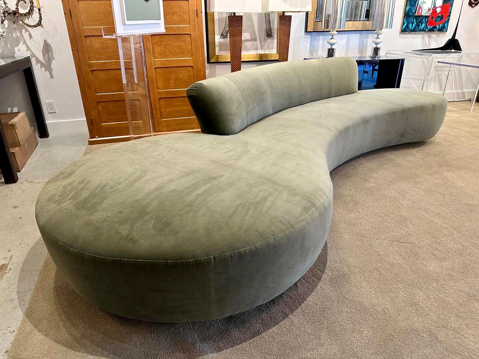 A large serpentine style sofa reupholstered in sage green velvet.  Although there was no label attached, it is very possible this is designed by Vladimir Kagan.