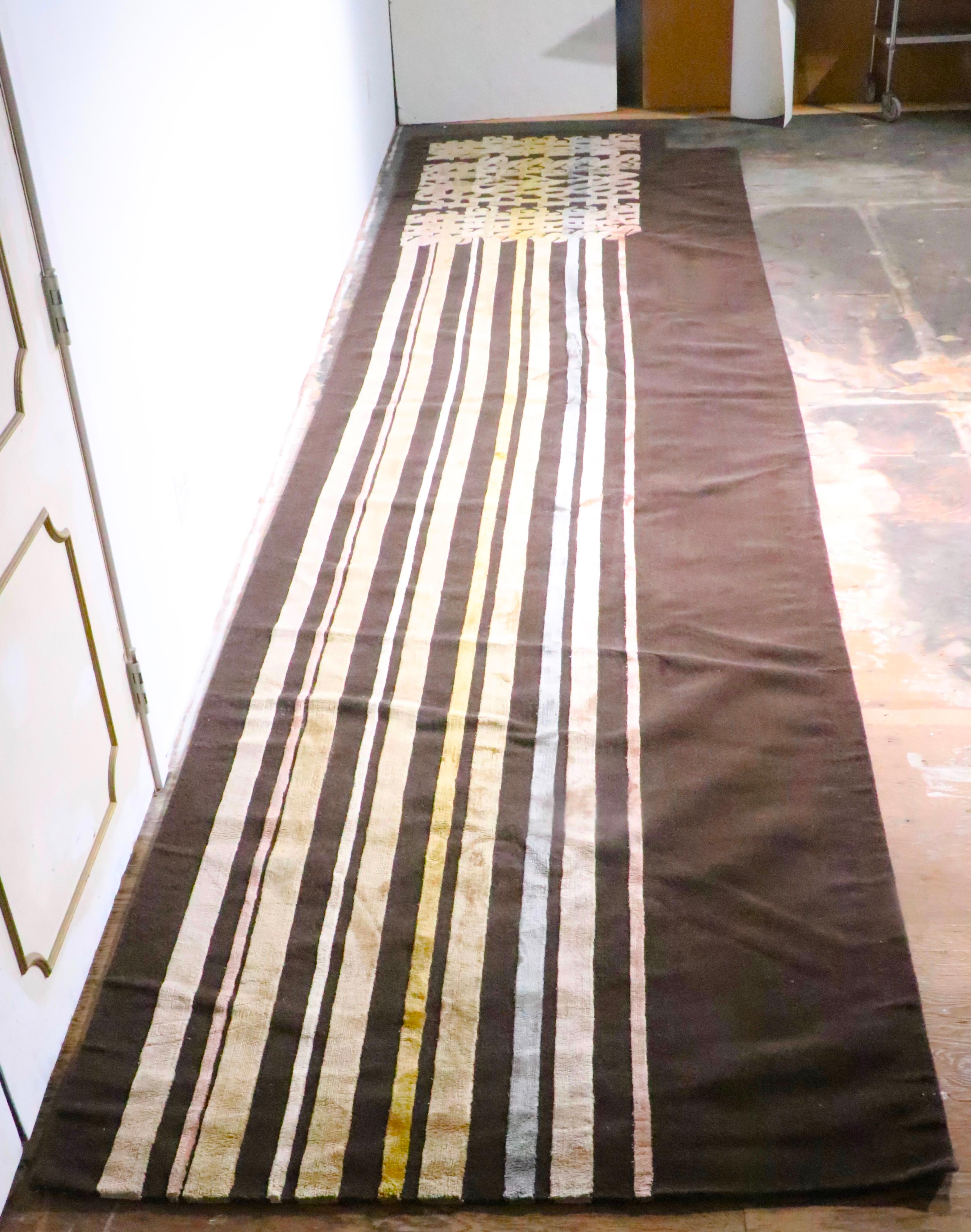 Unusual extra long carpet runner, by The Rug Company. The rug features colored bands  which run the  length of the rug and become the phrase She Loves Me at one end. Constructed of thick wool and silk pile, hand made and of exceptional design and