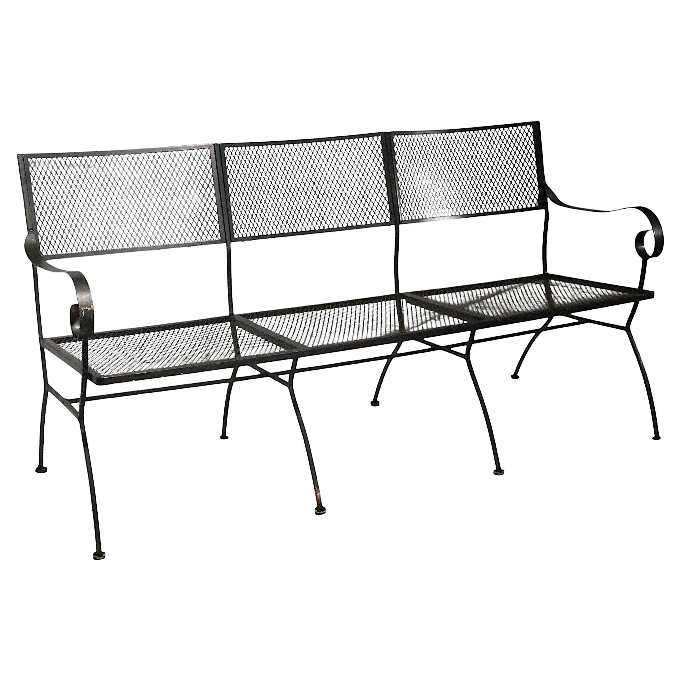   Unusual large vintage  wrought iron outdoor garden, patio, poolside bench, having three seats, curled armrests with metal mesh seats and back rests. This example is in very good, original, clean and ready to use condition, showing only light