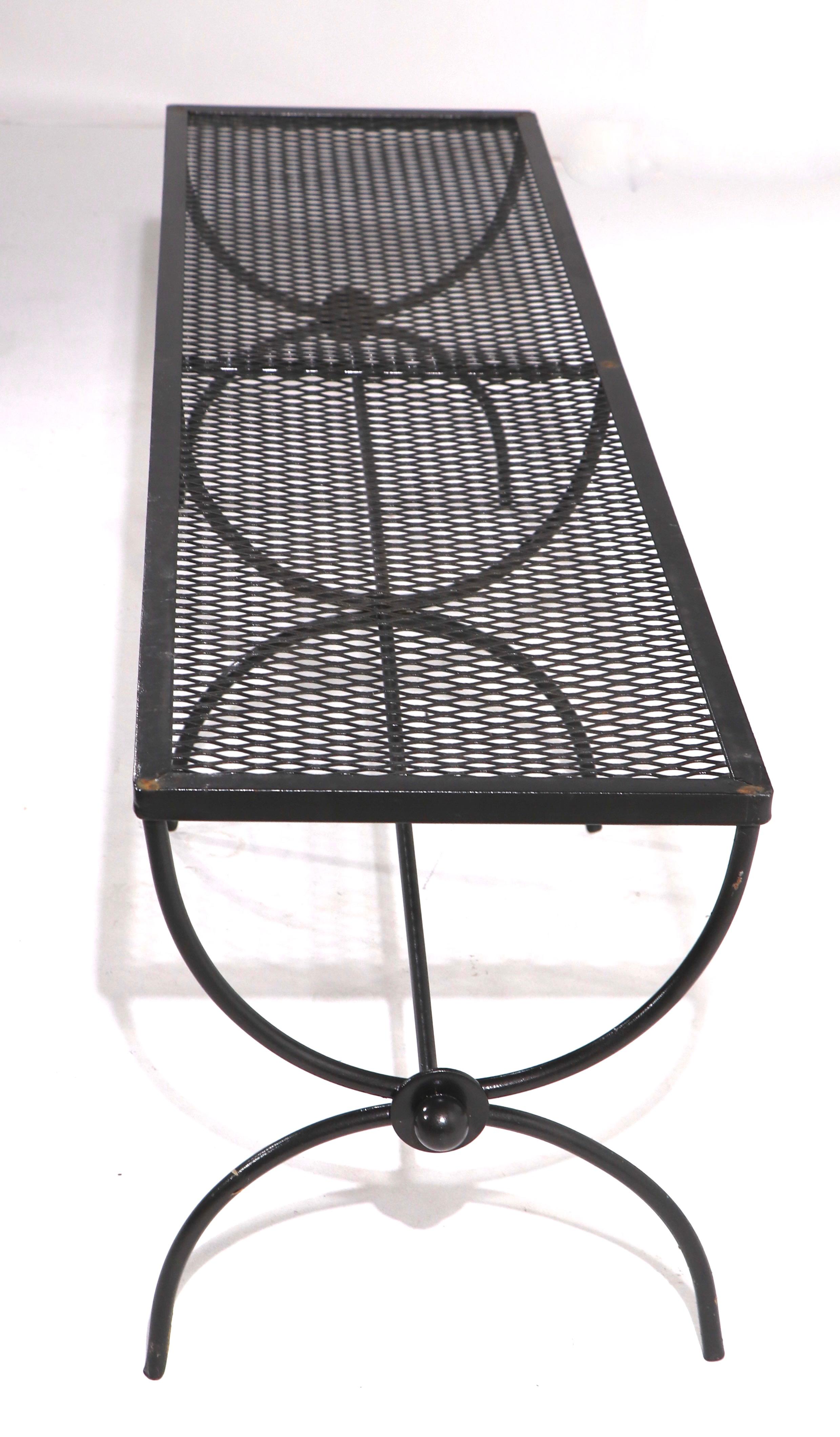 Chic architectural garden, patio, poolside bench by Salterini. The base is wrought iron which supports a metal mesh top. Unusually large scale, each bench measures 54 inch W. Recently painted in semi gloss black paint, both are clean and ready to