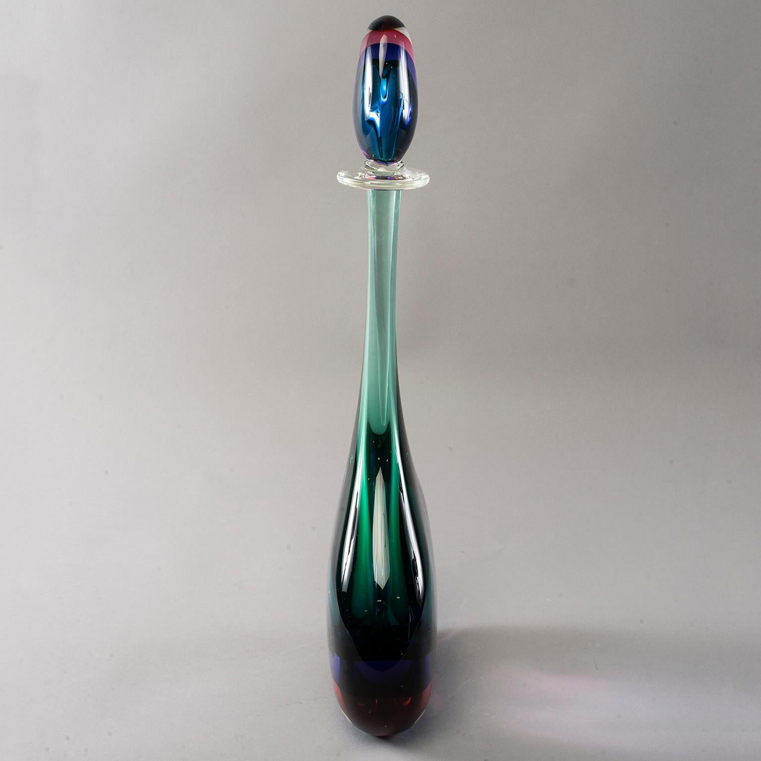 Extra tall Murano glass sommerso style bottle with perfume style stopper. Clear outer layer of glass with magenta, sapphire and emerald layers of color in both bottle and stopper. New, with no flaws found. 