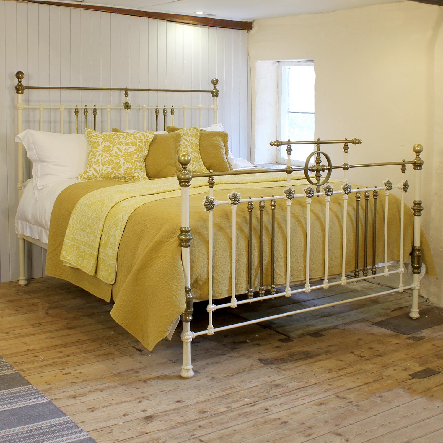 An attractive 6ft wide (72 inches) brass and iron antique bed finished in cream with brass decoration, gallery with central ring on the foot panel, decorative castings and straight brass top rails, adapted and extended from an original Victorian