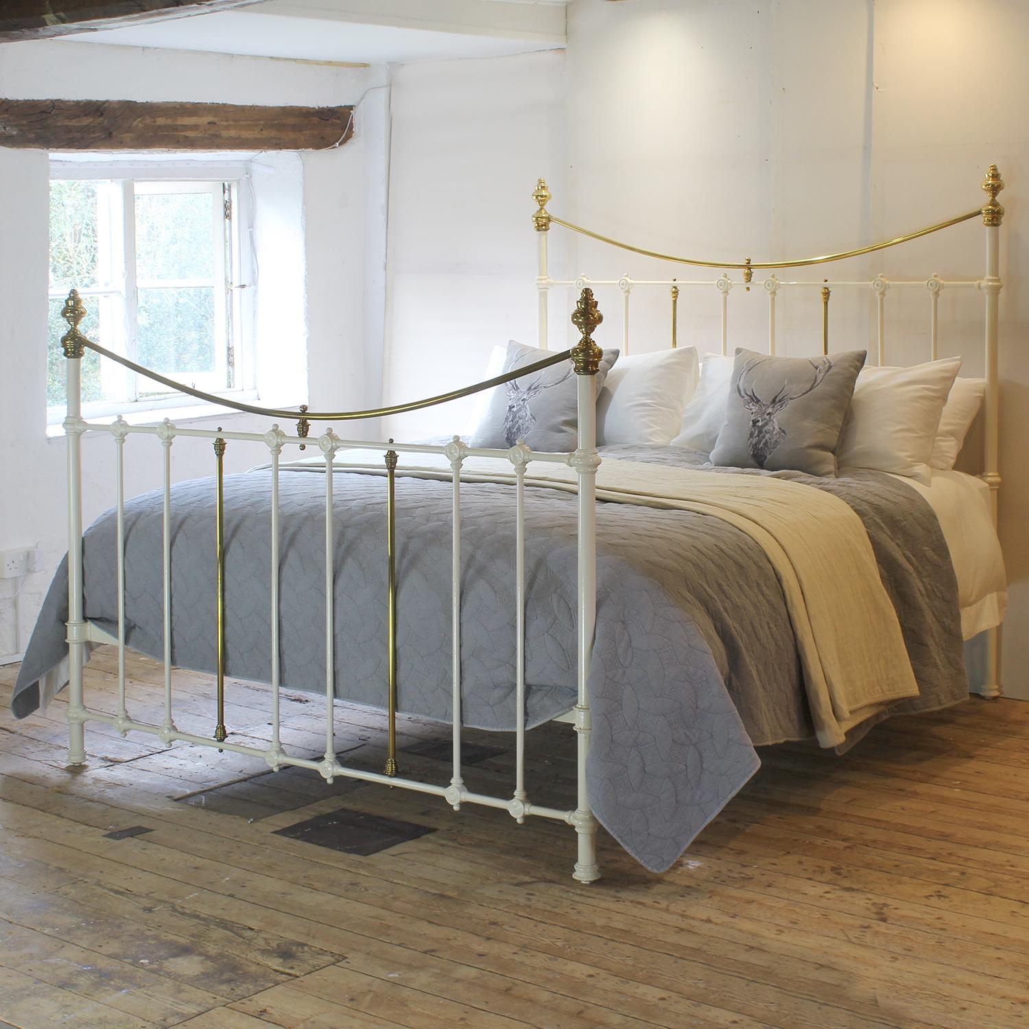 An attractive 6ft wide (72 inches) brass and iron bedstead finished in cream with curved brass top rails, adapted and extended from an original Victorian frame, circa 1895. The brass work has acquired a tarnished patina over the years, but can be