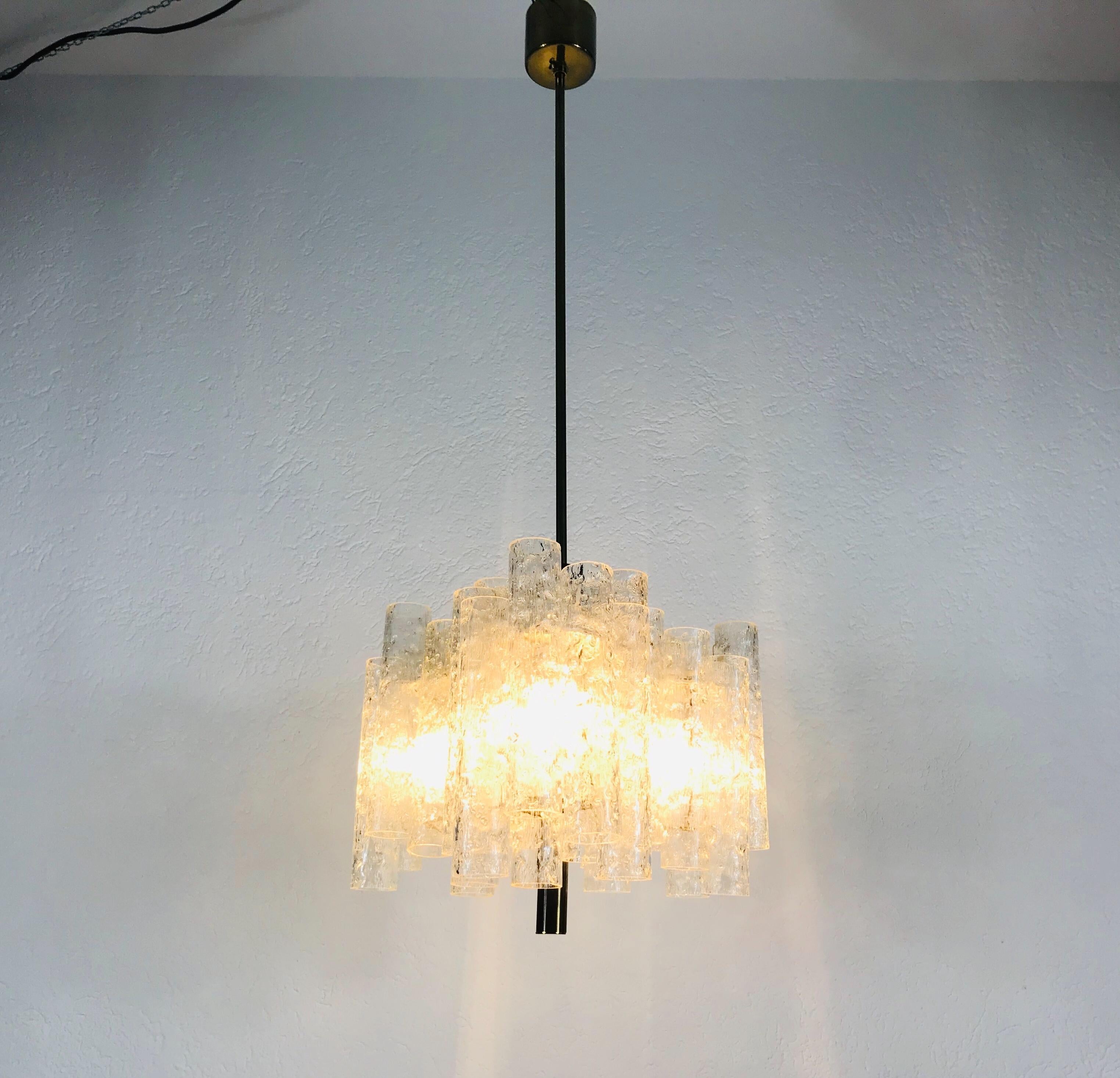 A Doria ice glass chandelier made in Germany in the 1960s. It is fascinating with its rare glass tubes which are secure to the body in different heights. Brass body with three arms, each with frosted glass tubes. There is a polished brass disc on