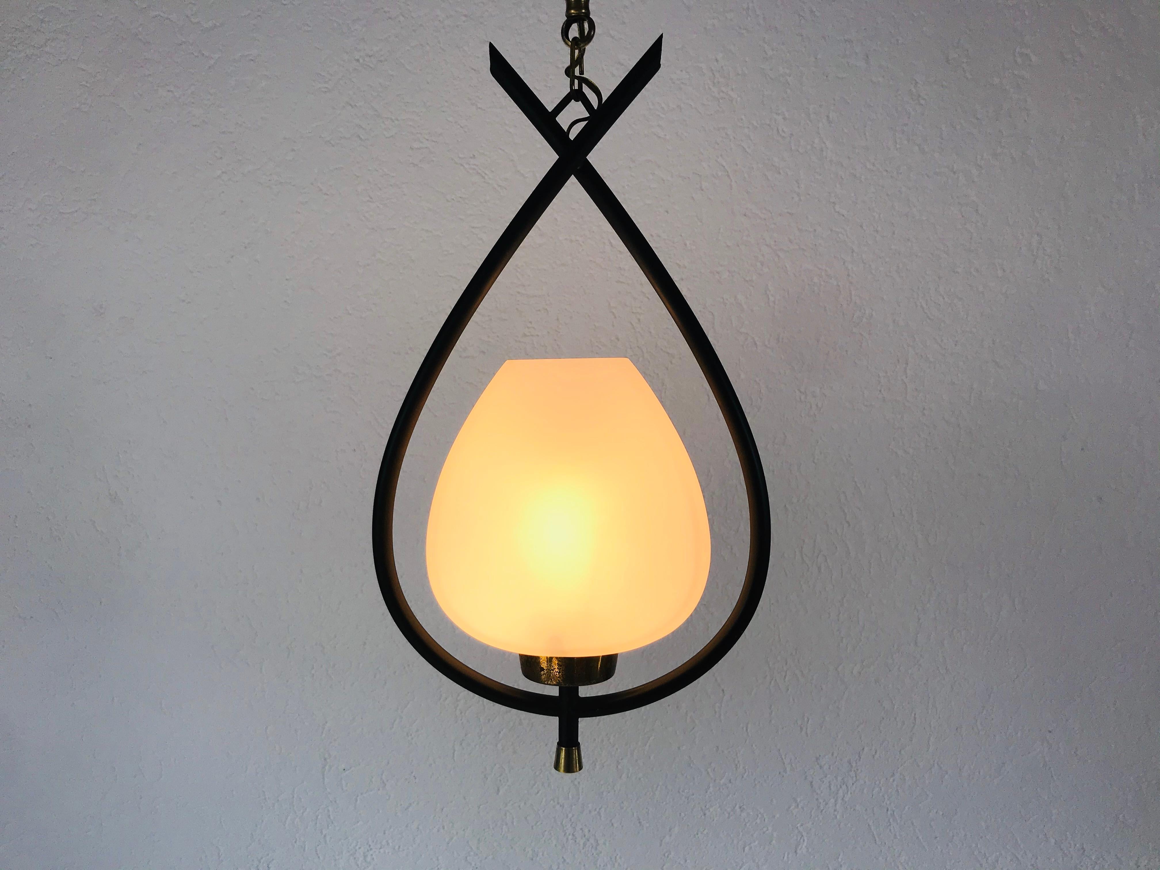 Very rare pendant lamp from Maison Lunel from the 1950s. The light has a black thin metal body with an opaline glass. There are brass parts on the bottom of the fixture. The chain is also made of brass.

The light requires one B15 light bulbs.